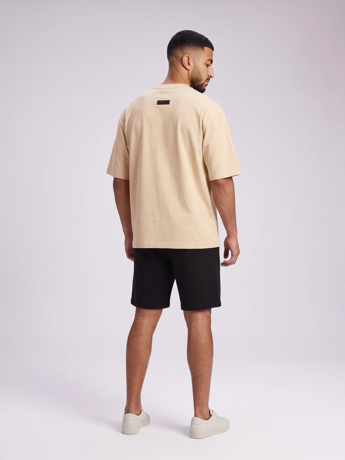 Beige oversized t-shirt, Unidentity Foundation Oversized Tee, full-length back view of the oversized silhouette and minimal 3D patch, 210gsm #color_beige