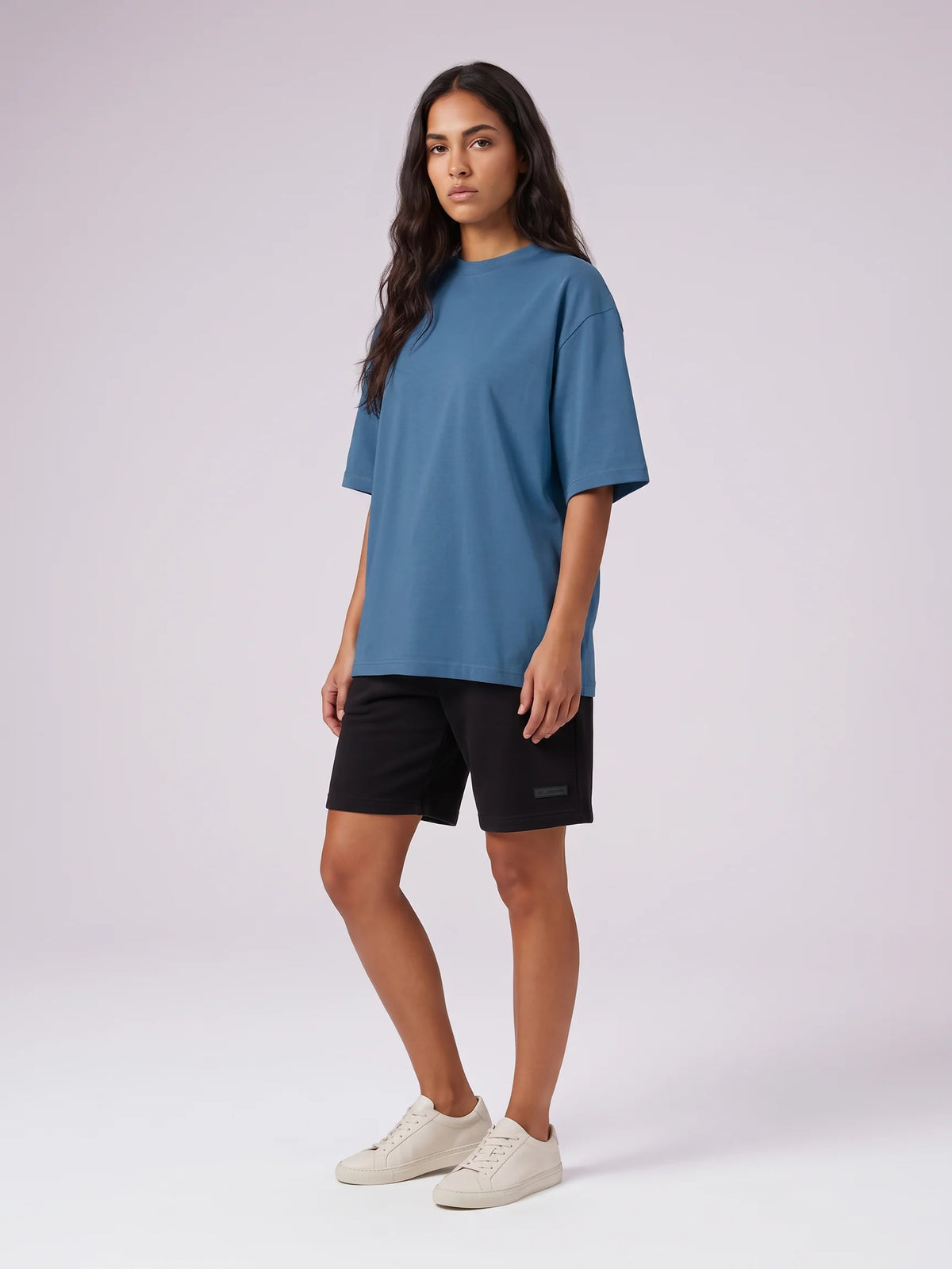 Blue oversized t-shirt in organic cotton, Unidentity Foundation Tee, full-length front view worn by woman in a relaxed crew neck fit, 210gsm #color_blue