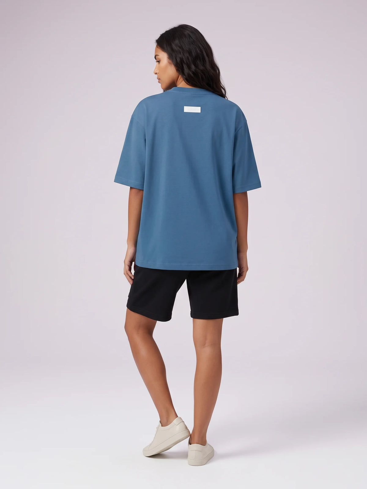 Blue heavyweight oversized t-shirt, Unidentity Foundation Oversized Tee, full-length back view worn by woman with black Core shorts, streetwear #color_blue