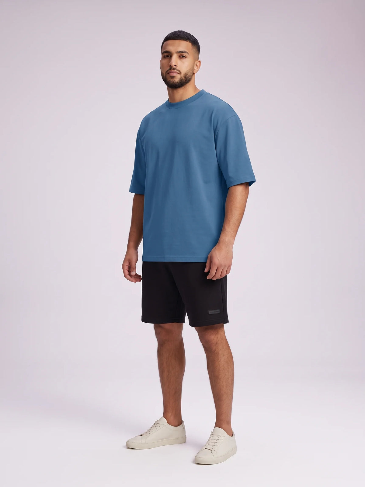 Blue organic cotton t-shirt, Unidentity Foundation Oversized Tee, full-length front view of the no-graphic design with black Core shorts, streetwear #color_blue