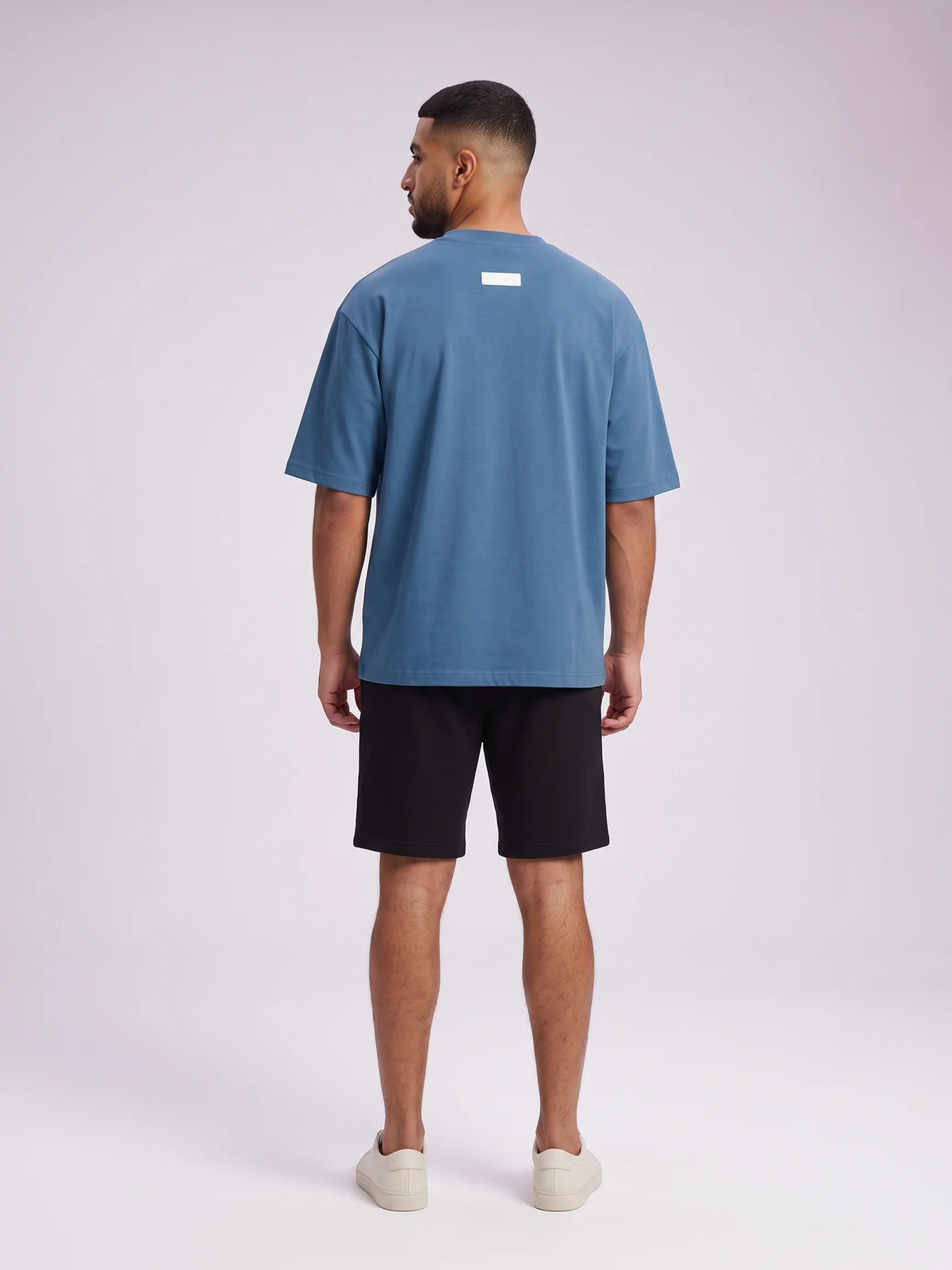 Blue organic cotton t-shirt, Unidentity Foundation Oversized Tee, full-length back view worn by man showing the 3D patch, streetwear brand in Dubai #color_blue