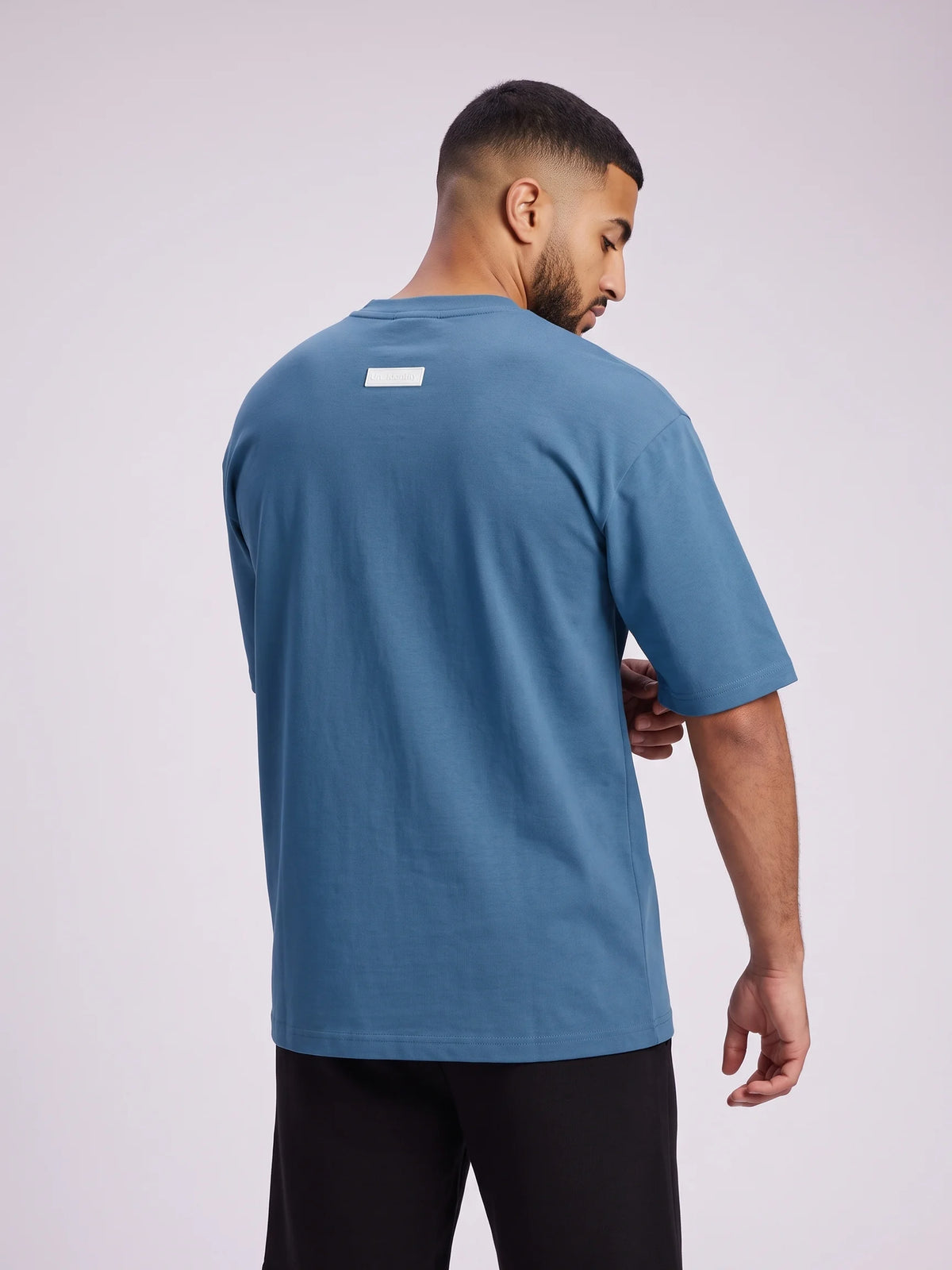 Blue heavyweight oversized t-shirt in organic cotton, Unidentity Foundation Tee, back close-up of the white 3D patch, 210gsm streetwear from Dubai #color_blue
