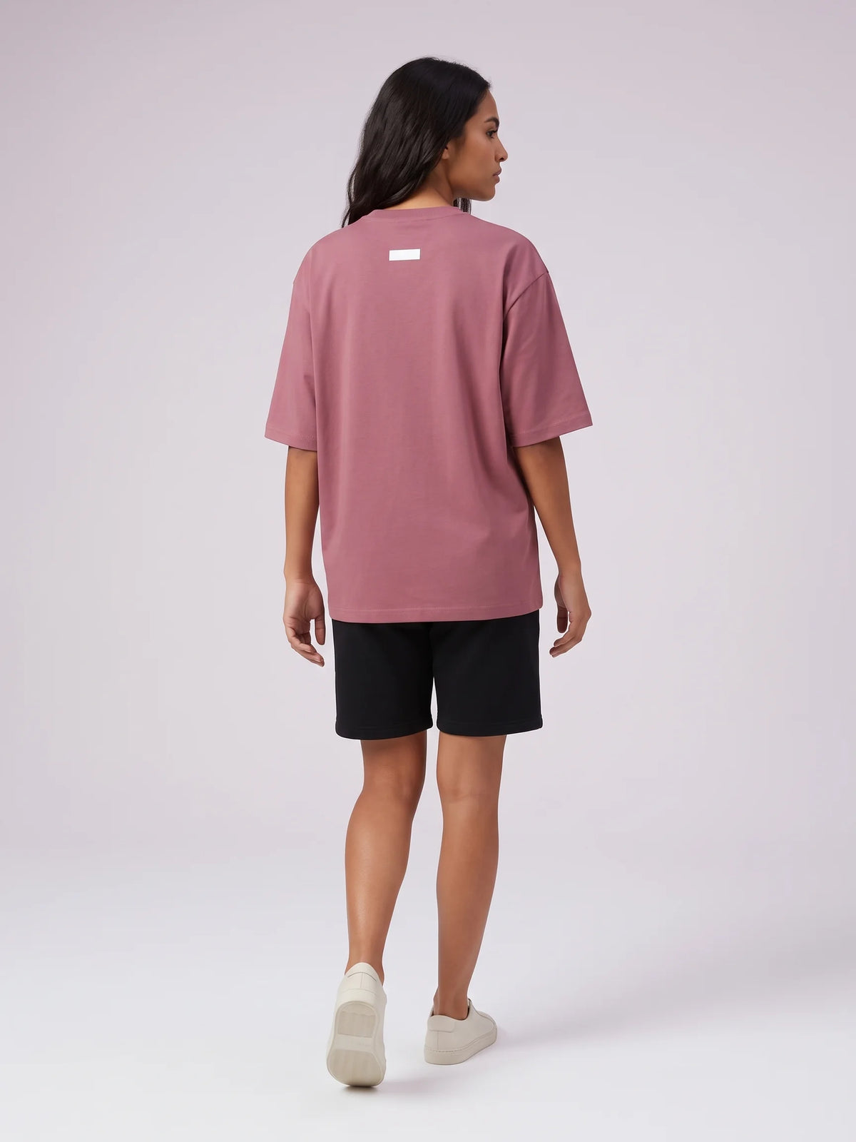 Plum oversized t-shirt, Unidentity Foundation Oversized Tee, full-length back view worn by woman with black Core shorts, streetwear brand in Dubai #color_plum