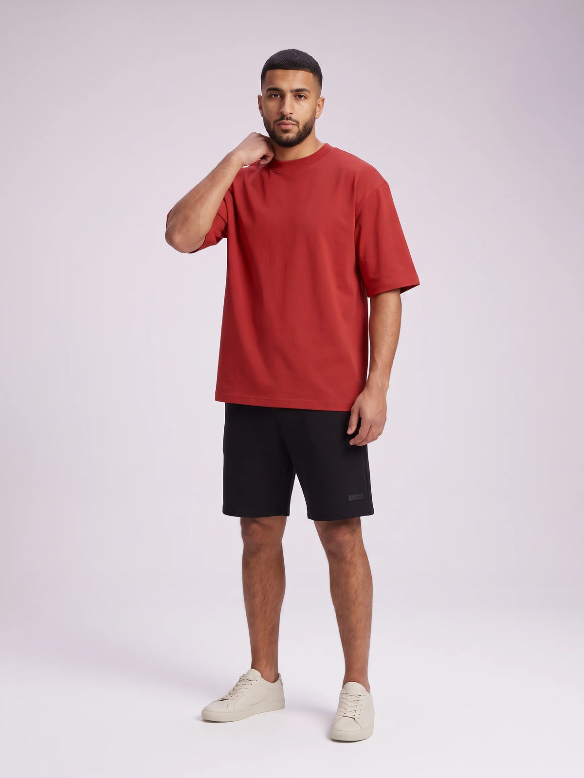 Red oversized t-shirt in organic cotton, Unidentity Foundation Tee, full-length front view on a man showing the wide short sleeves, Dubai streetwear #color_red