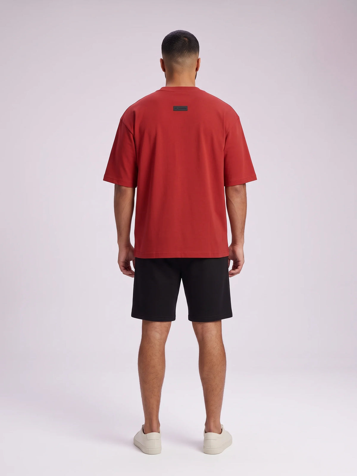 Red oversized t-shirt, Unidentity Foundation Oversized Tee, full-length back view of the oversized fit on a man with black Core shorts, UAE streetwear #color_red