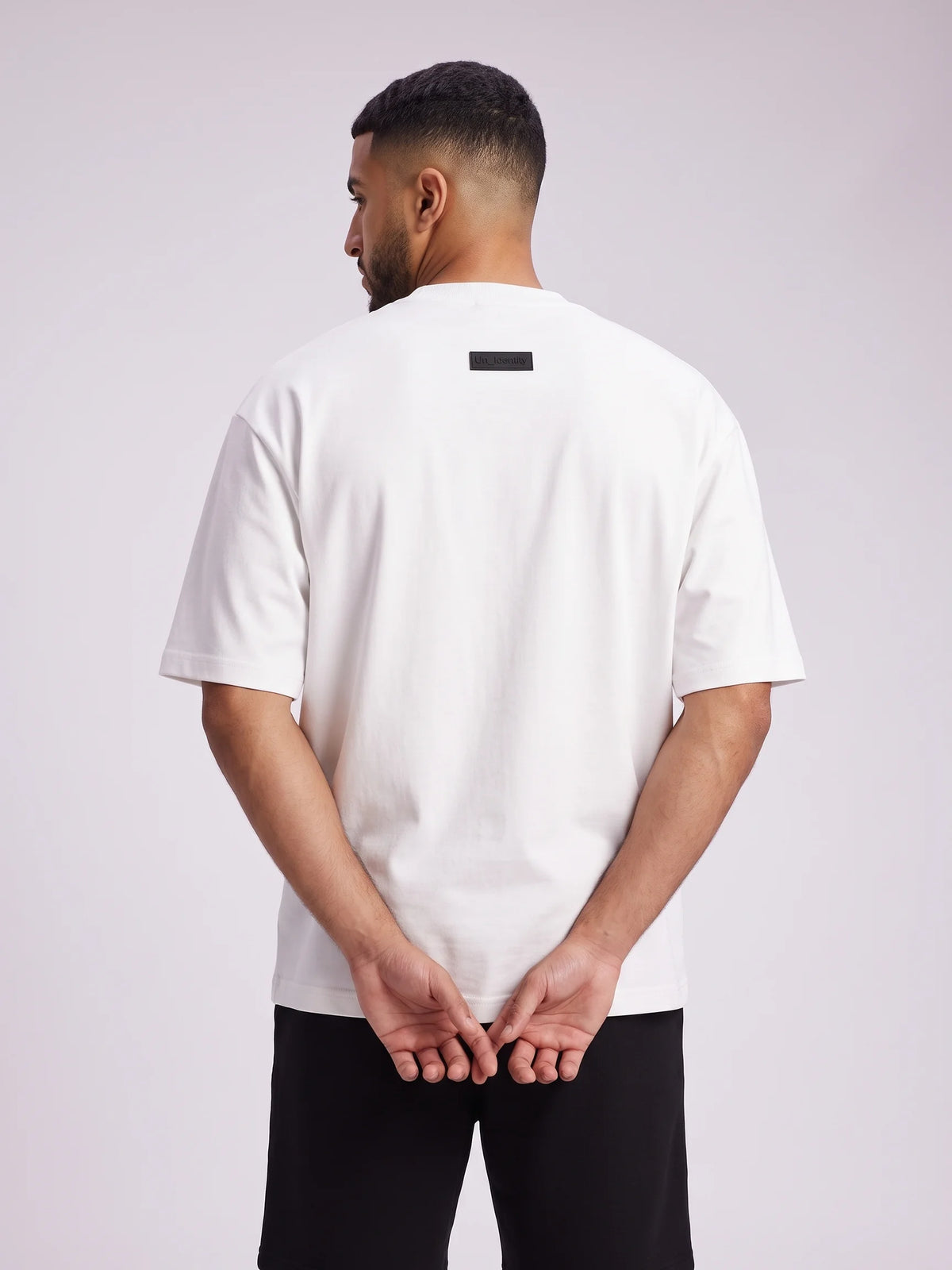 White heavyweight oversized t-shirt in organic cotton, Unidentity Foundation Tee, back close-up of the black 3D patch, 210gsm streetwear from Dubai #color_white