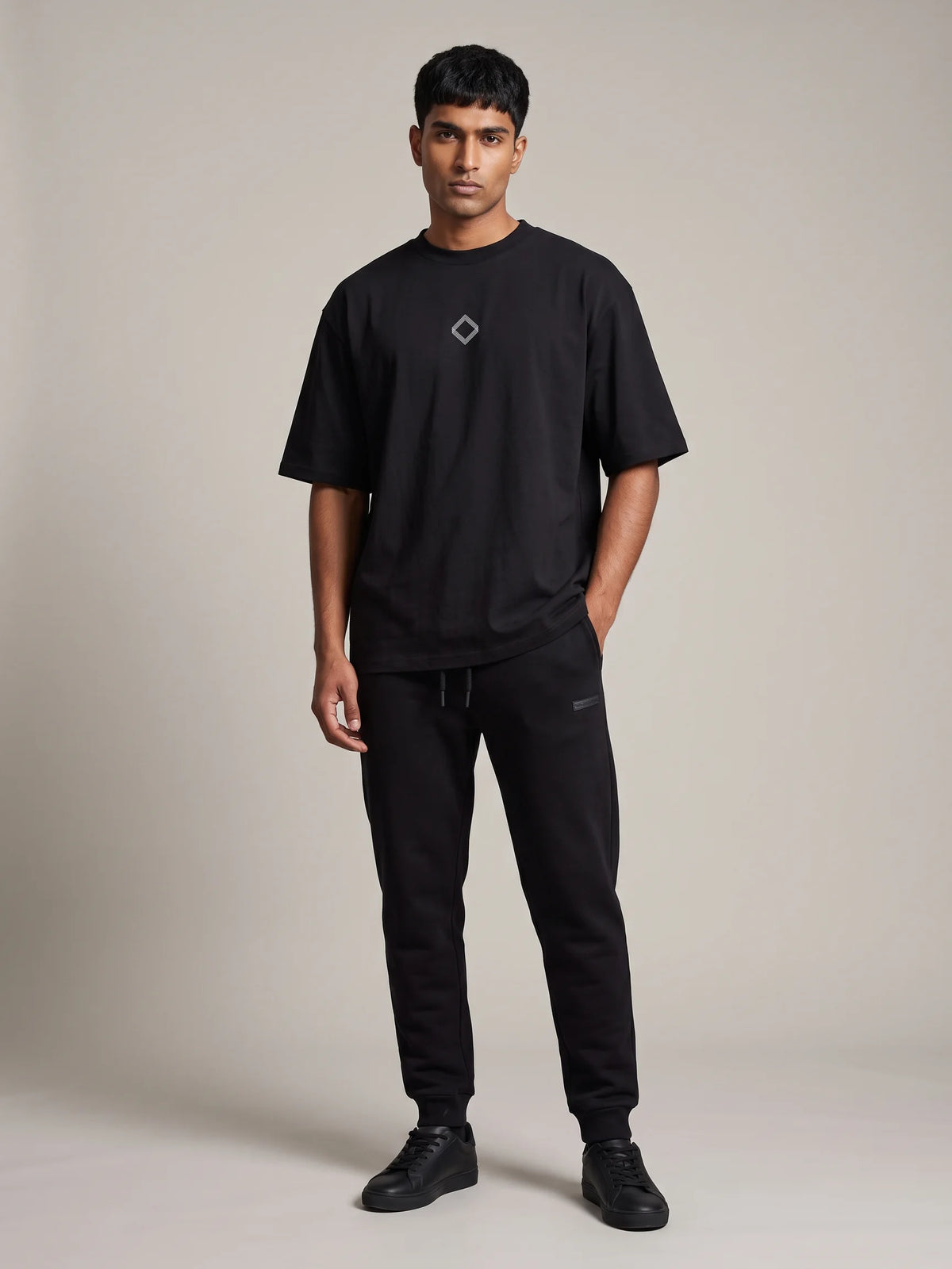 Black oversized t-shirt, Unidentity Trace Tee, full-length front view with black Core Regular Fit Joggers, UAE streetwear #color_black