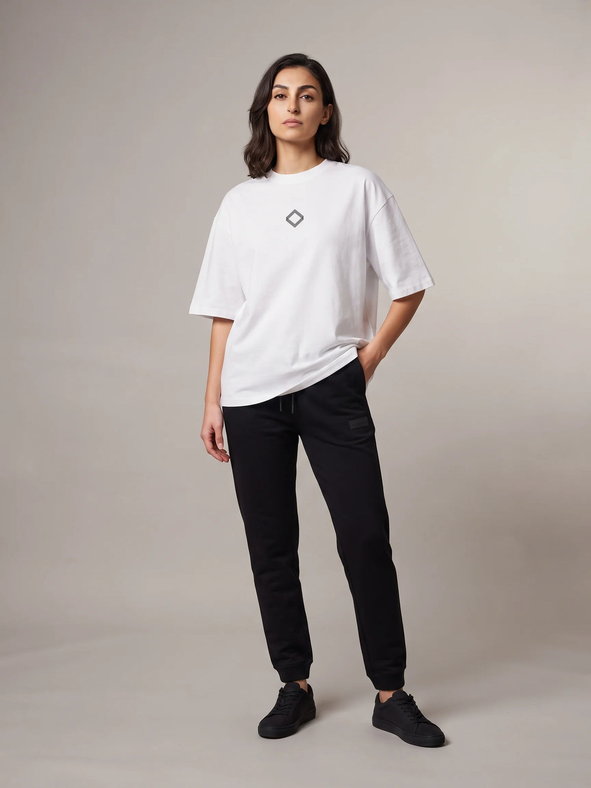 White oversized t-shirt, Unidentity Trace Tee, full-length front view worn by woman showing the small diamond chest logo, 210gsm #color_white