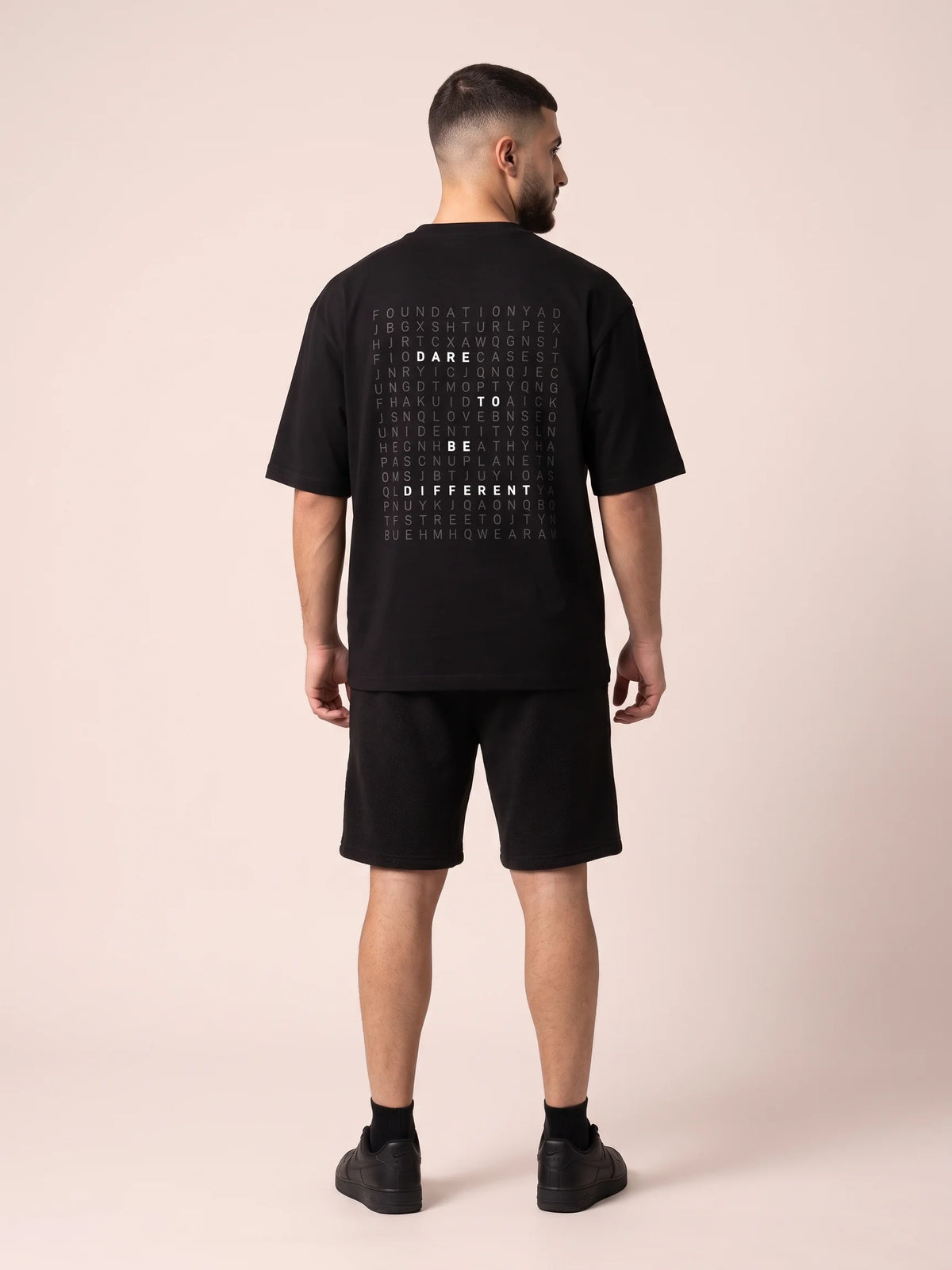 Black oversized t-shirt in organic cotton, Unidentity Dare Tee, full-length back view of the word search print with black Core shorts, streetwear #color_black