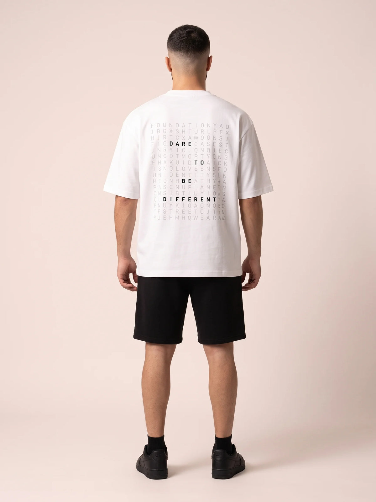 White heavyweight oversized t-shirt, Unidentity Dare Tee, full-length back view of the word search print with black Core shorts, sustainable fashion #color_white