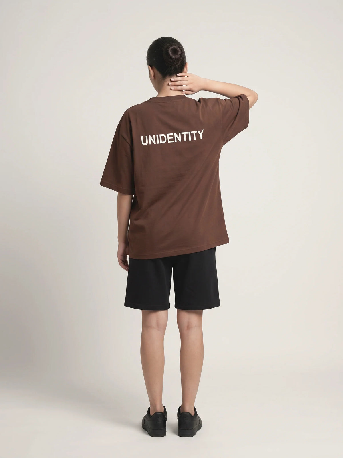 Chocolate oversized t-shirt, Unidentity You Oversized Tee, full-length back view worn by woman showing the UNIDENTITY back logo, sustainable fashion #color_chocolate