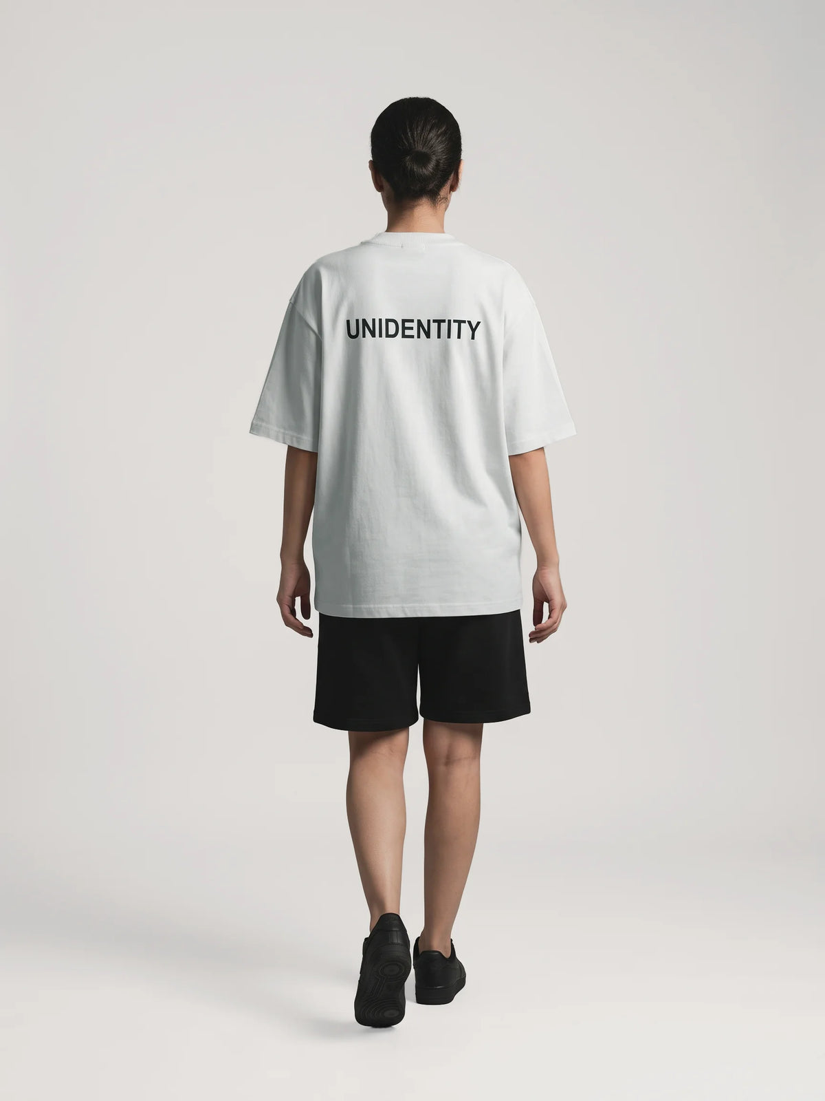 Gray heavyweight oversized t-shirt in organic cotton, Unidentity You Tee, full-length back view of the black UNIDENTITY logo, streetwear from Dubai #color_gray