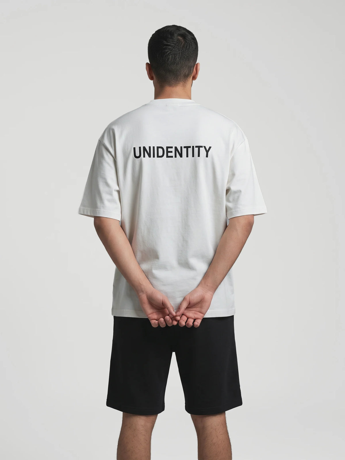 Gray oversized t-shirt, Unidentity You Oversized Tee, back view worn by man showing the black UNIDENTITY logo print, organic cotton #color_gray