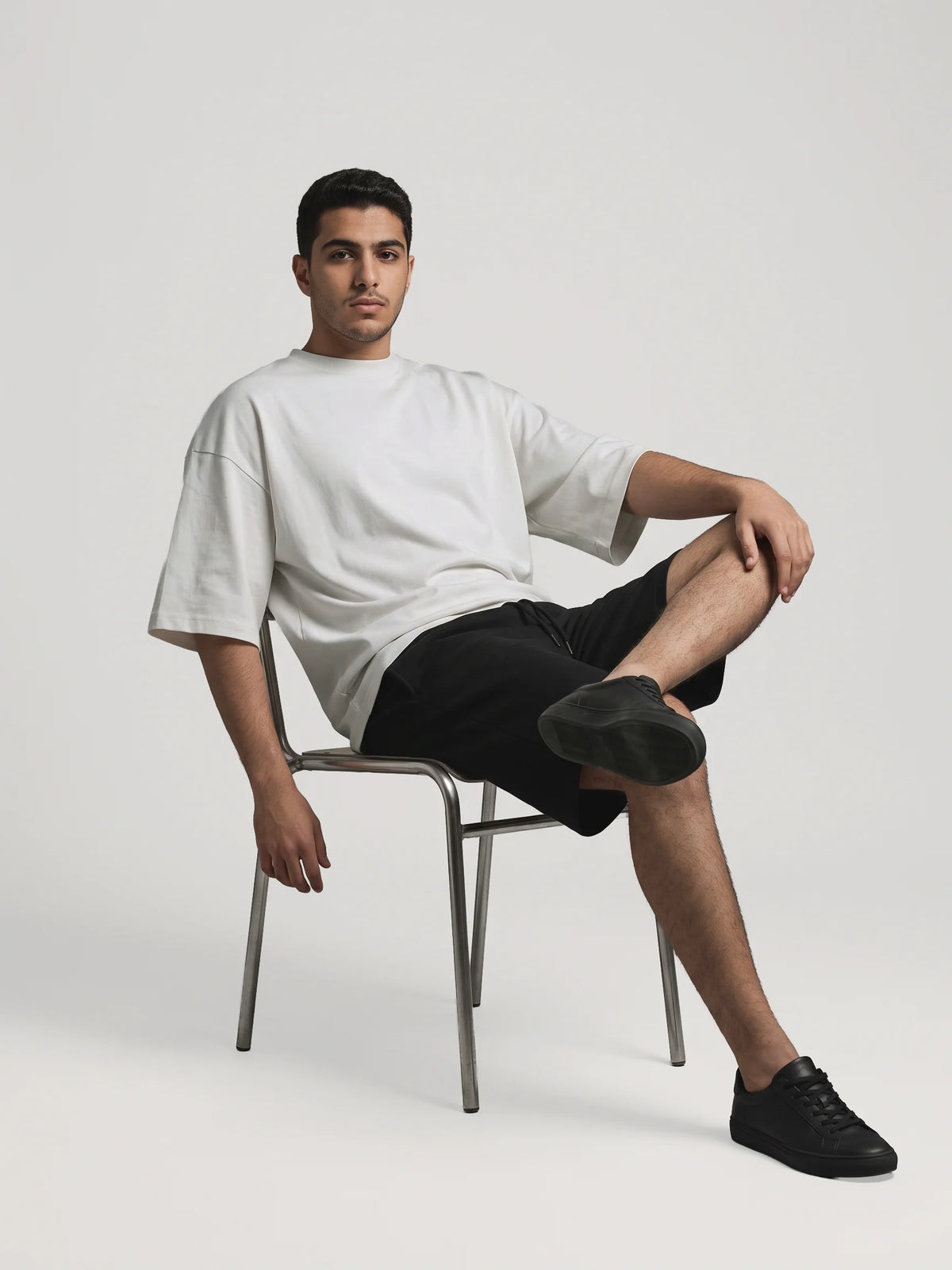 Gray oversized t-shirt, Unidentity You Tee, full-length front view of a seated man showing the dropped shoulders, UAE streetwear #color_gray