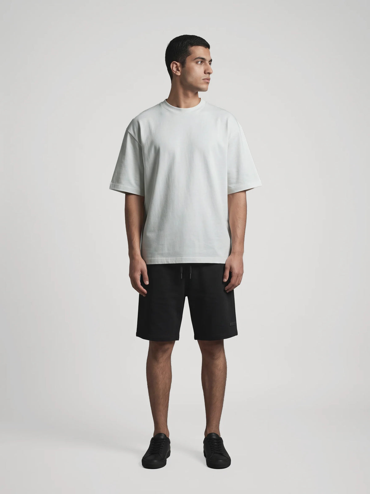 Gray oversized t-shirt in organic cotton, Unidentity You Oversized Tee, full-length front view worn by man with black Core shorts, streetwear #color_gray