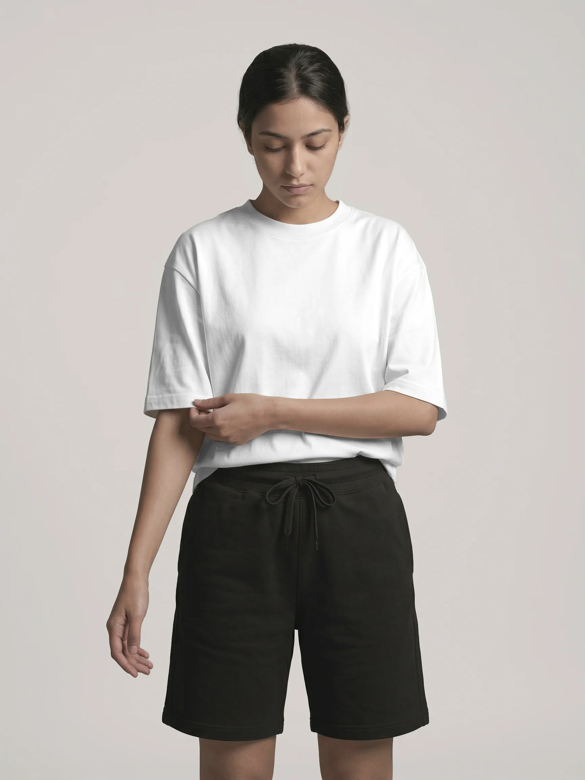White organic cotton t-shirt, Unidentity You Oversized Tee, front view worn by woman showing the clean crew neck with black Core Regular Fit Shorts #color_white