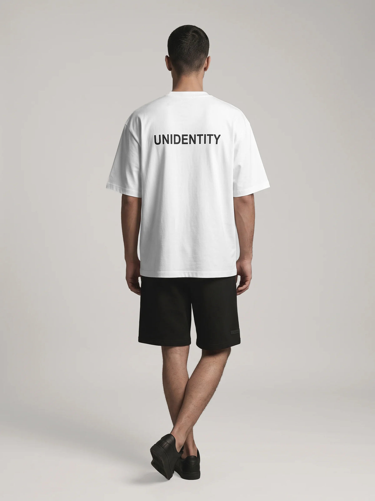 White heavyweight oversized t-shirt in organic cotton, Unidentity You Tee, full-length back view of the UNIDENTITY back logo, 210gsm, Dubai streetwear #color_white