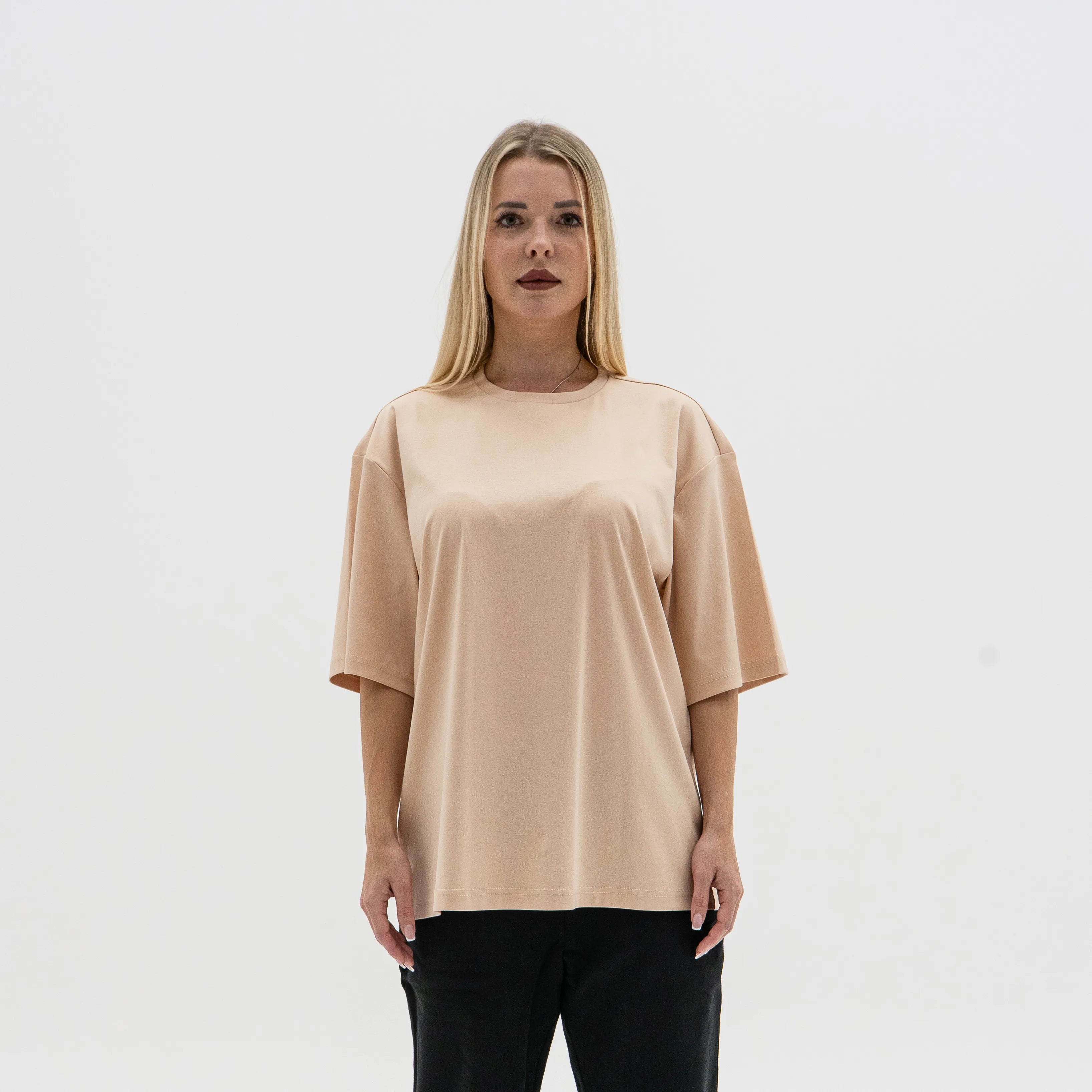 Woman wearing a beige oversized t-shirt against a white background. #color_beige