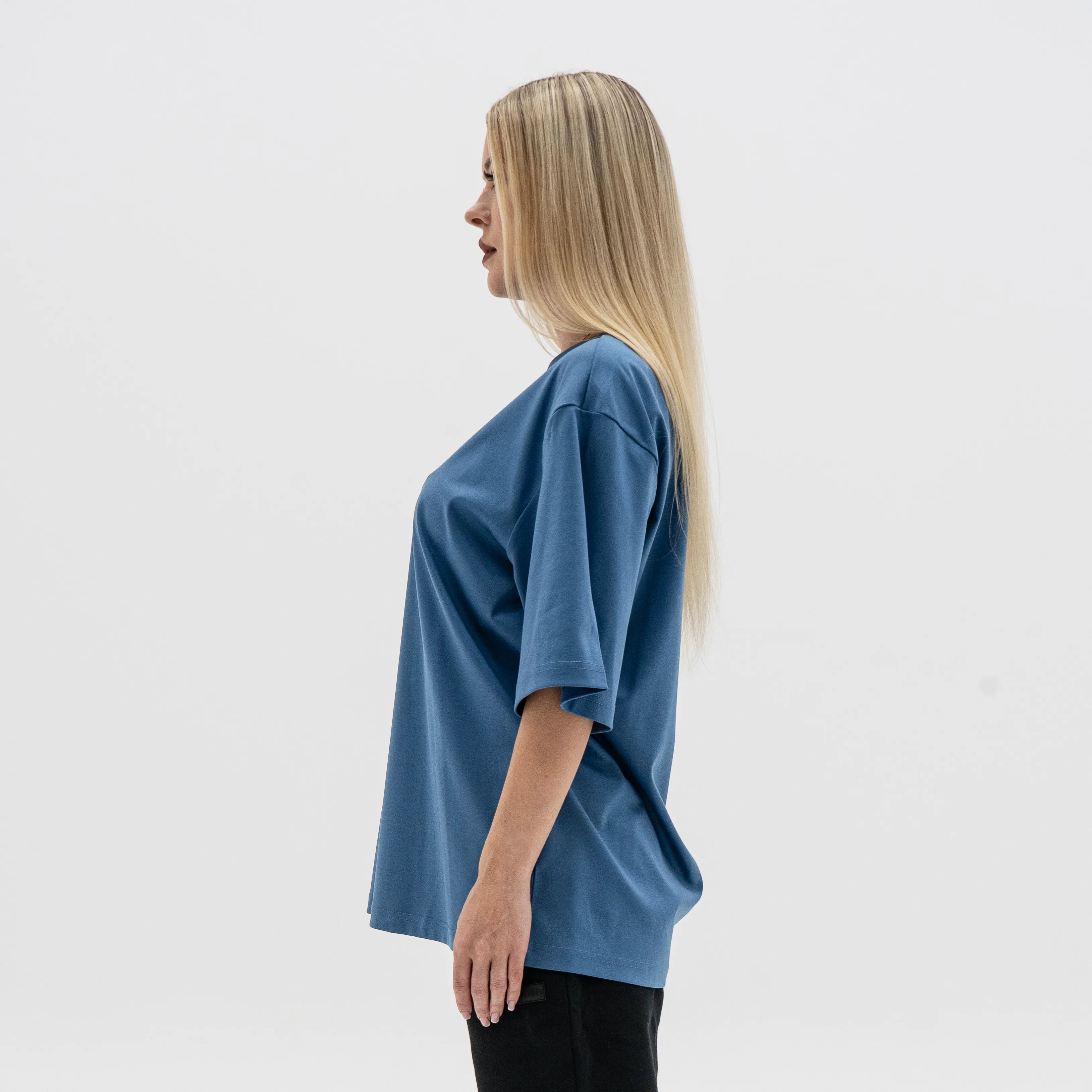 Woman wearing a blue oversized shirt against a white background. #color_blue