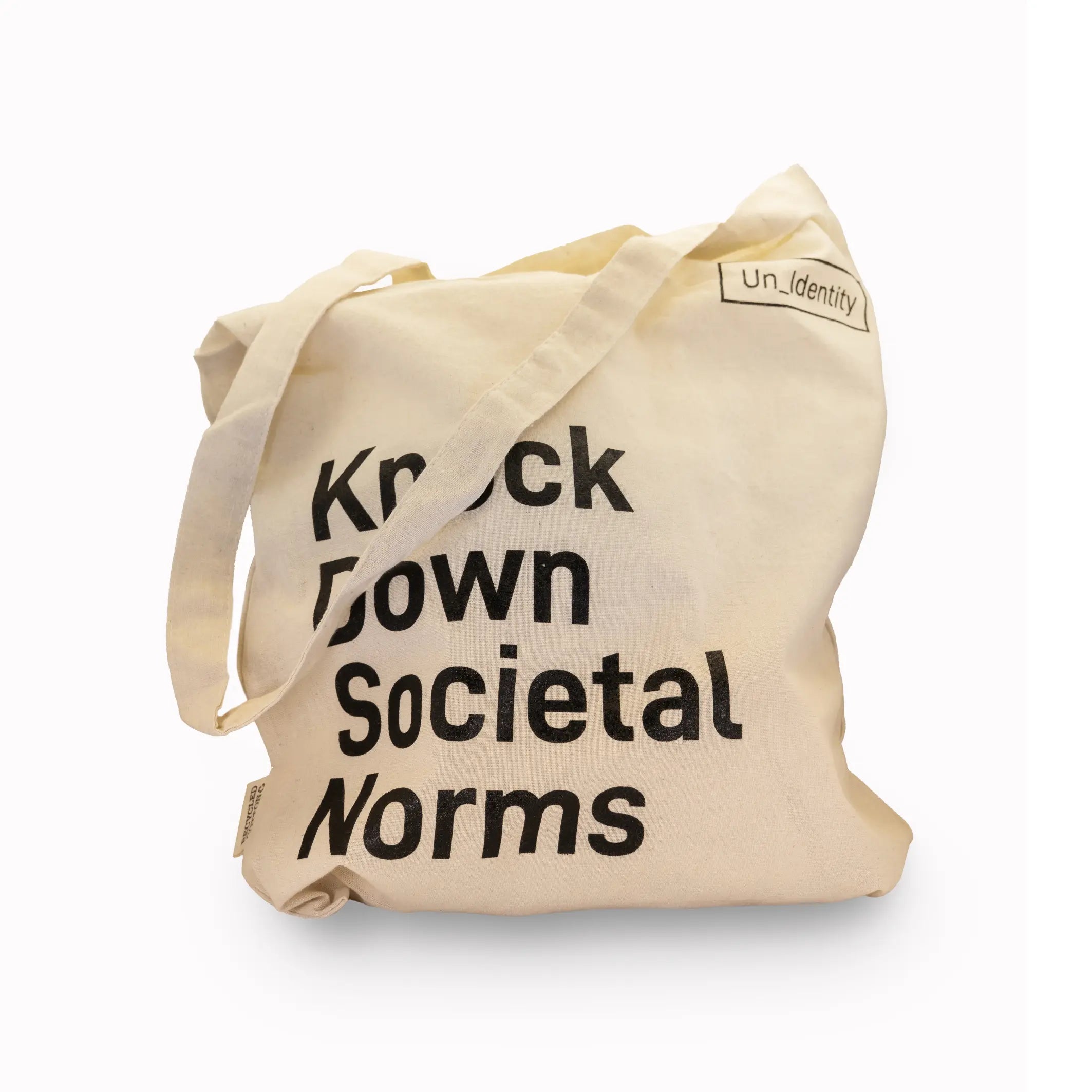 Beige Unidentity tote bag with black text 