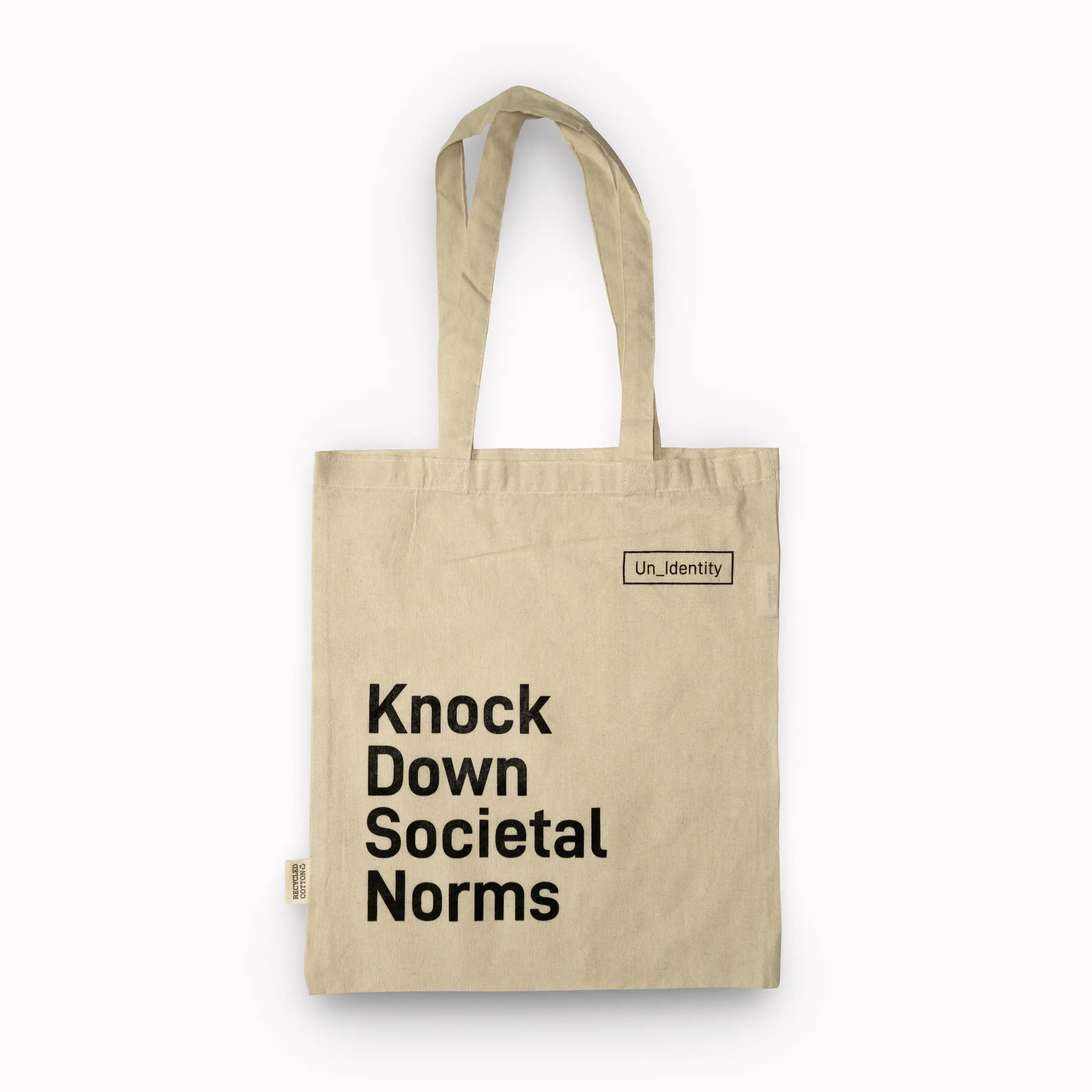 Beige Unidentity tote bag with Knock Down Societal Norms text 