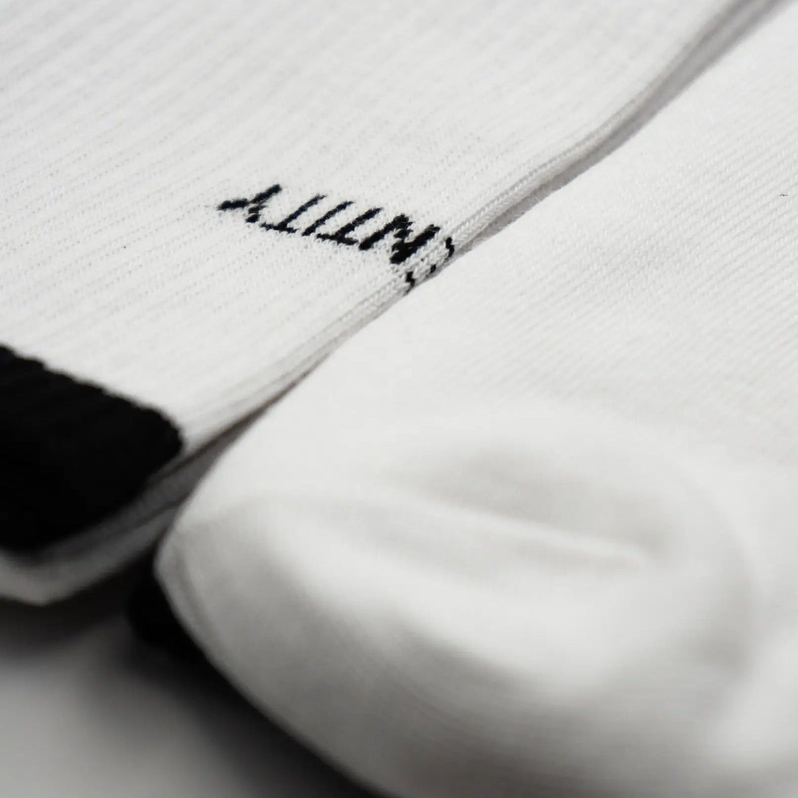 Close-up of white socks with black text 