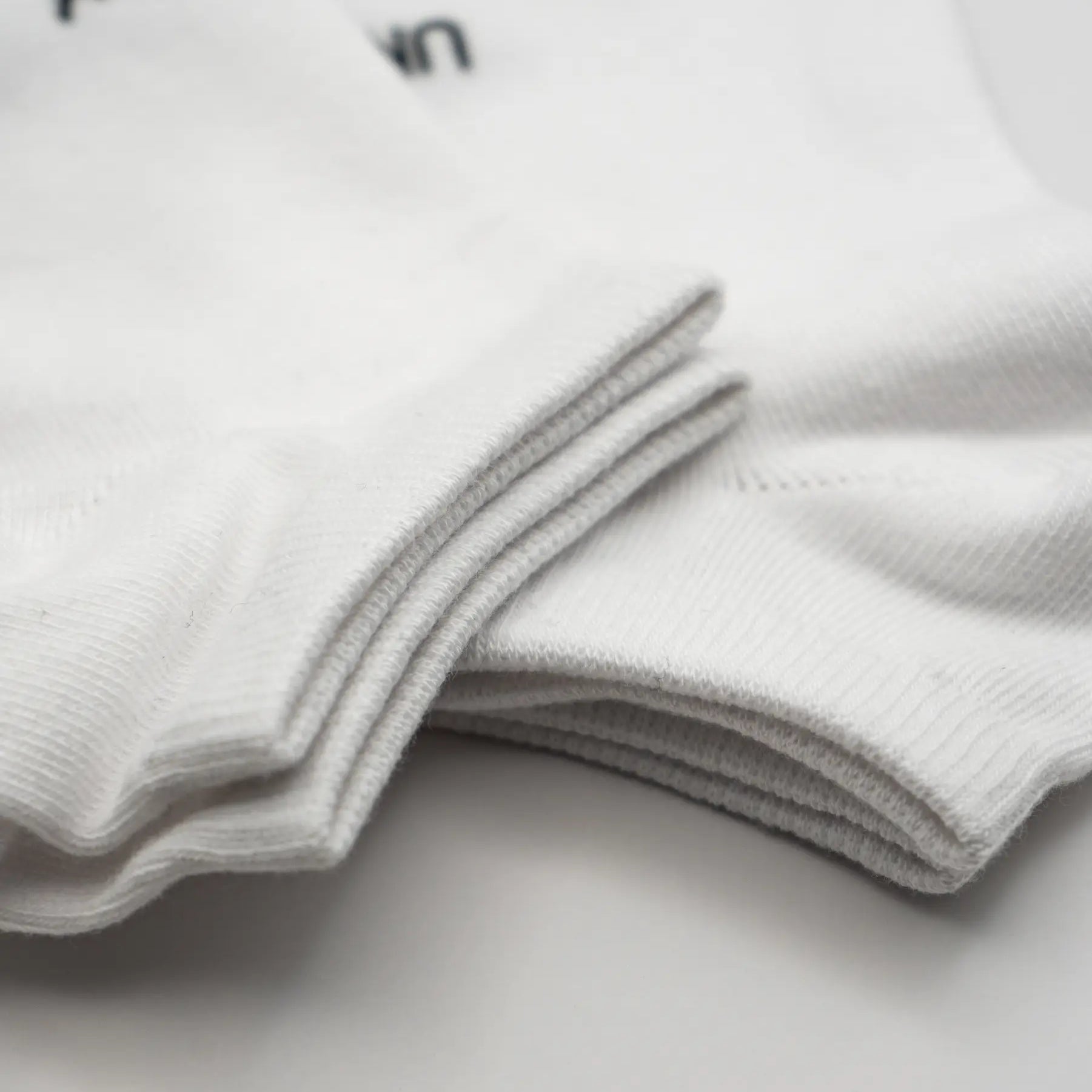 Close-up of cuffs of white socks. #color_white
