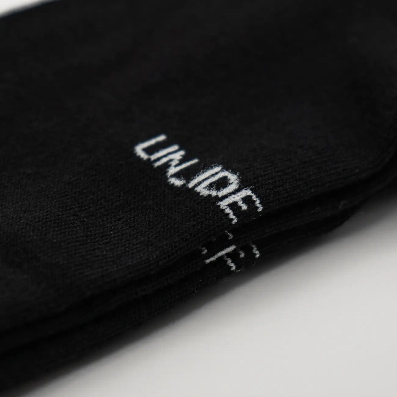 Close-up of black socks with white text. #color_black