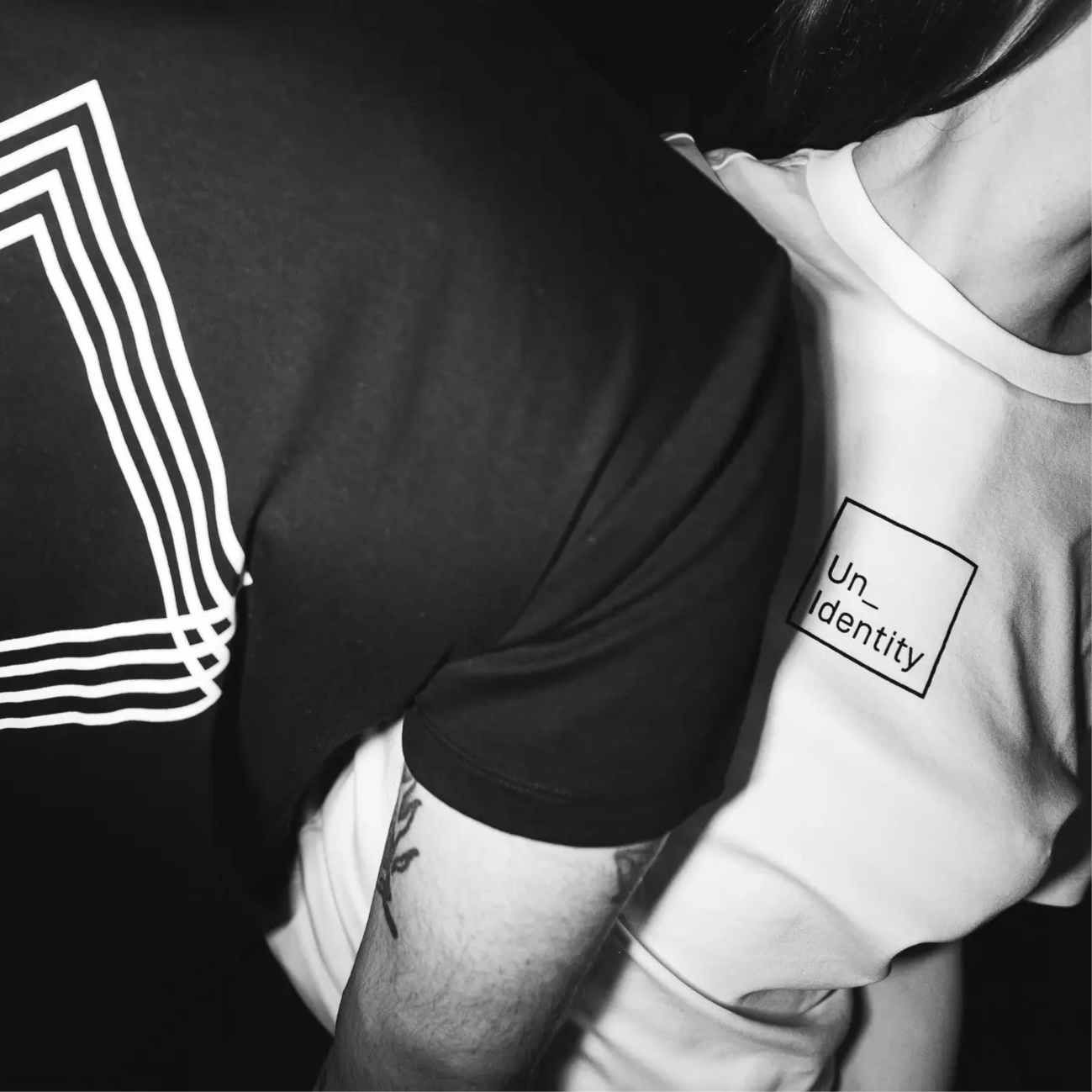 Couple wearing matching Unidentity tees. #color_white