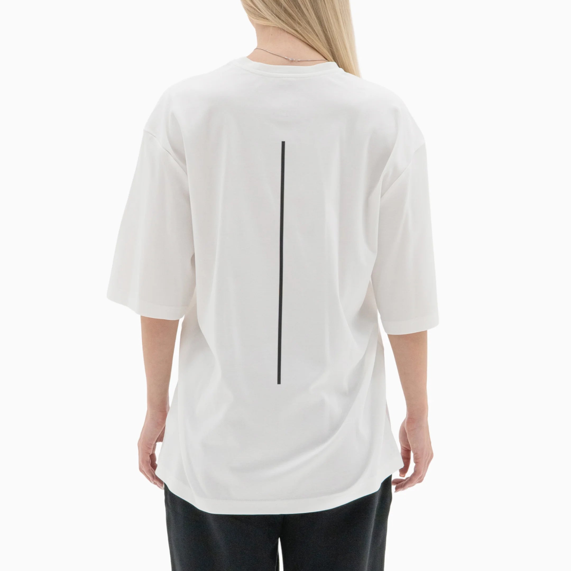 Person wearing a white t-shirt with a black line on the back against a plain background. #color_white