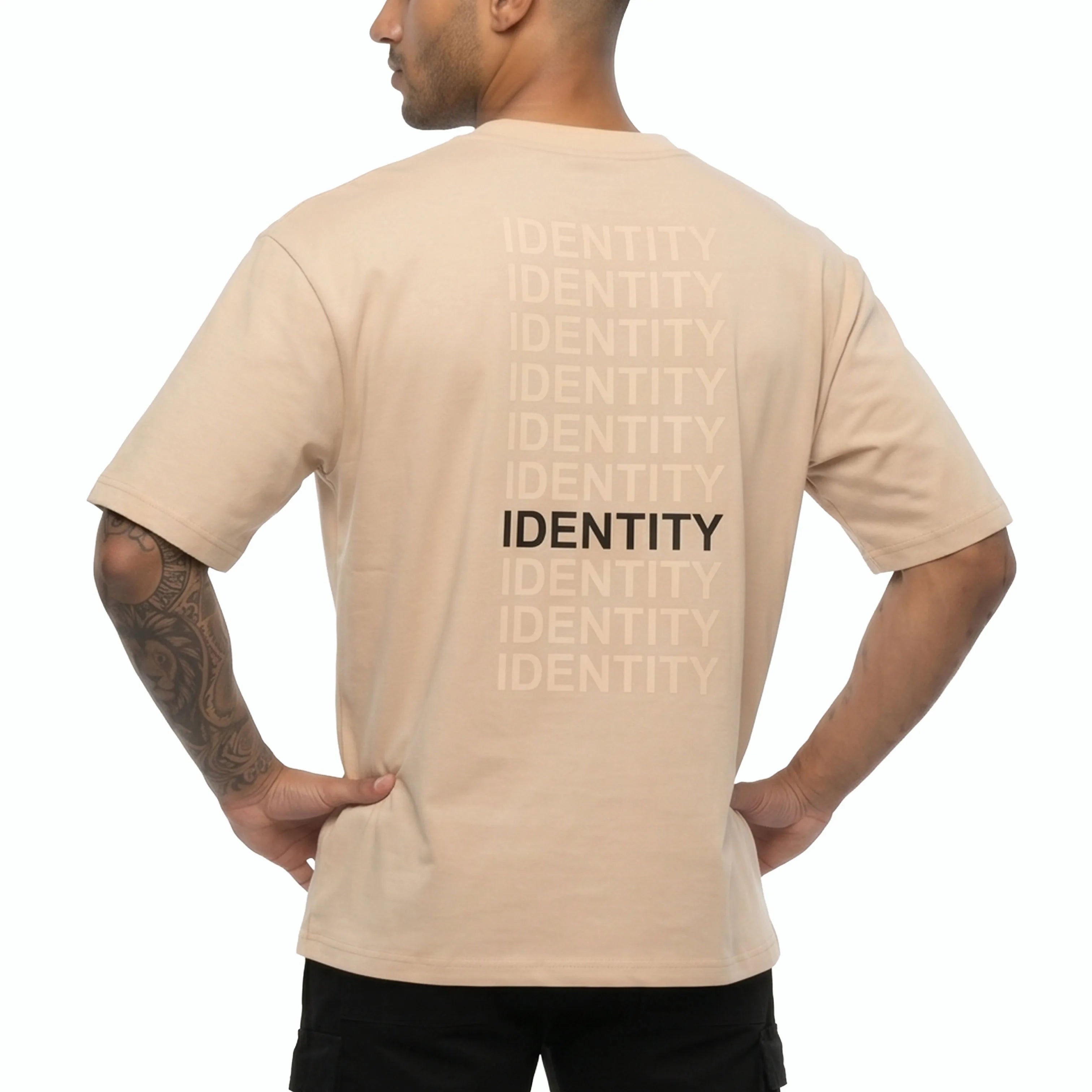 Person wearing beige Unidentity T-shirt with identity printed on the back. #color_beige