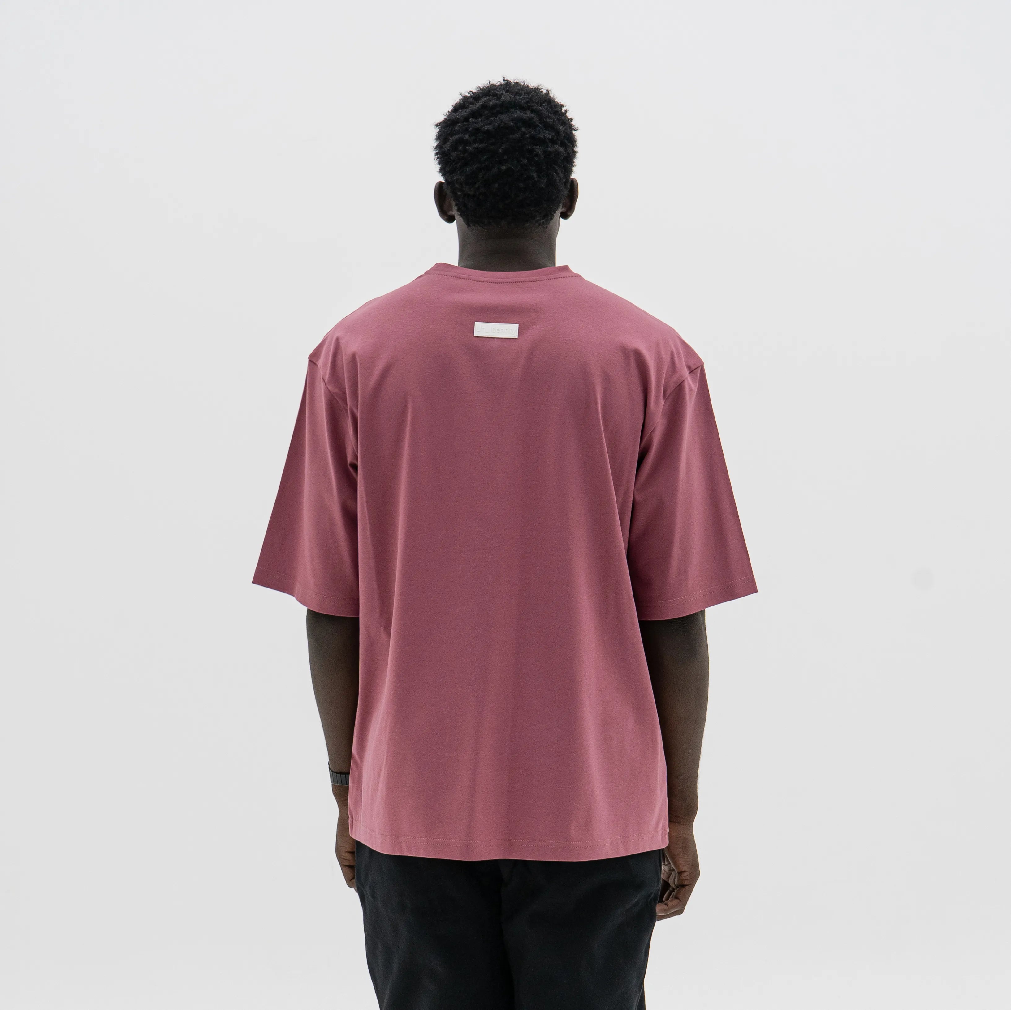 Person wearing a maroon t-shirt on a white background. #color_plum