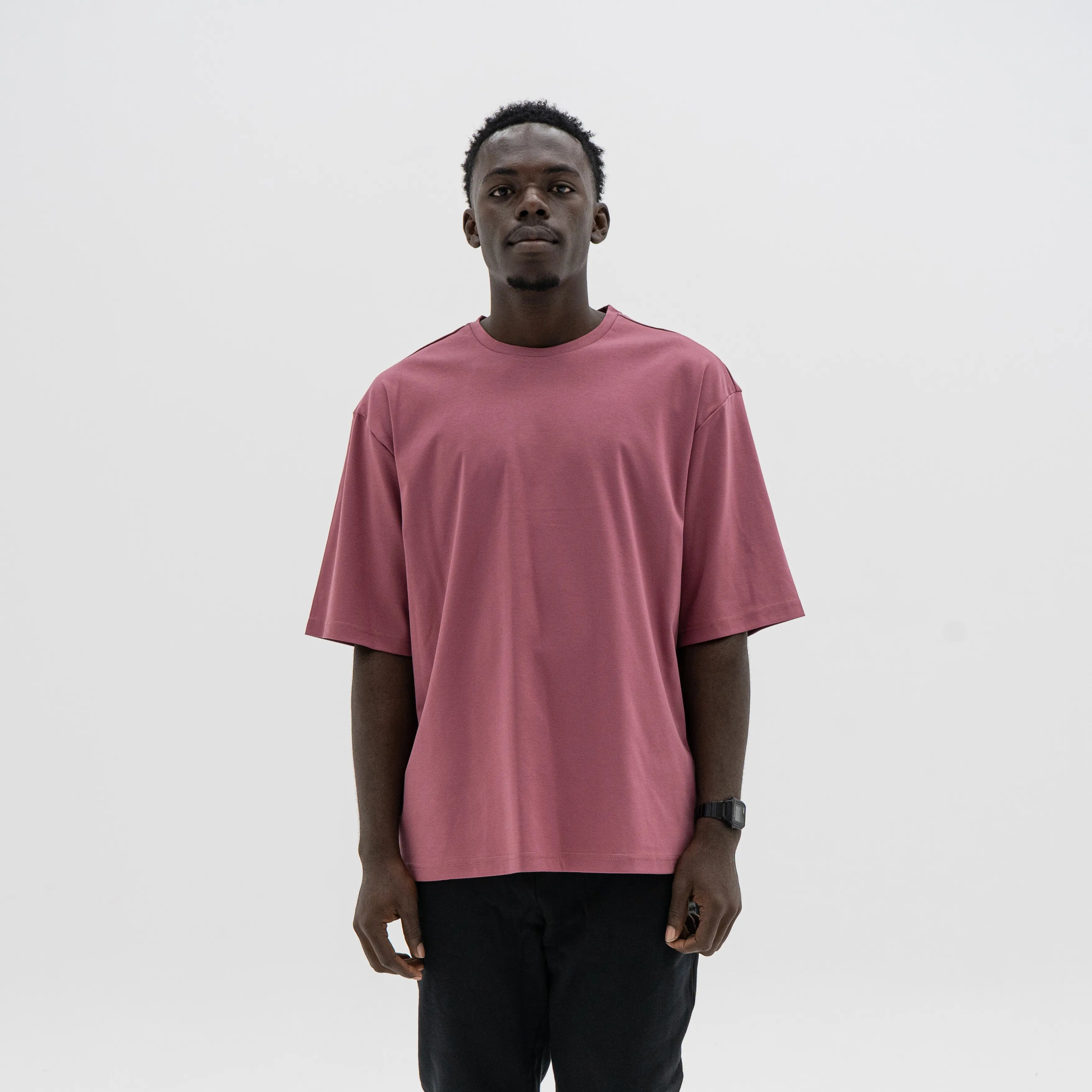 Person wearing a maroon t-shirt against a plain background. #color_plum