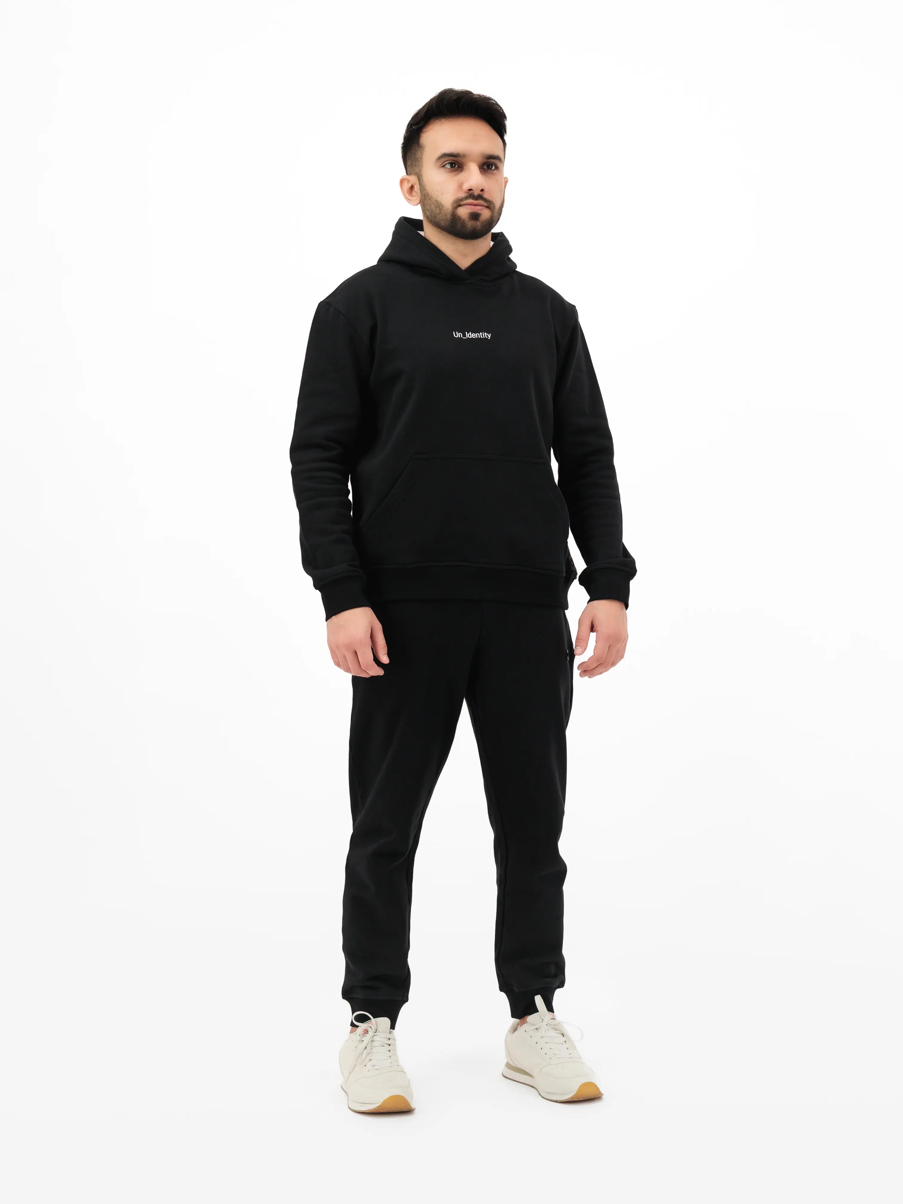 Model wearing black Unidentity hoodie with brand logo and pants. #color_black
