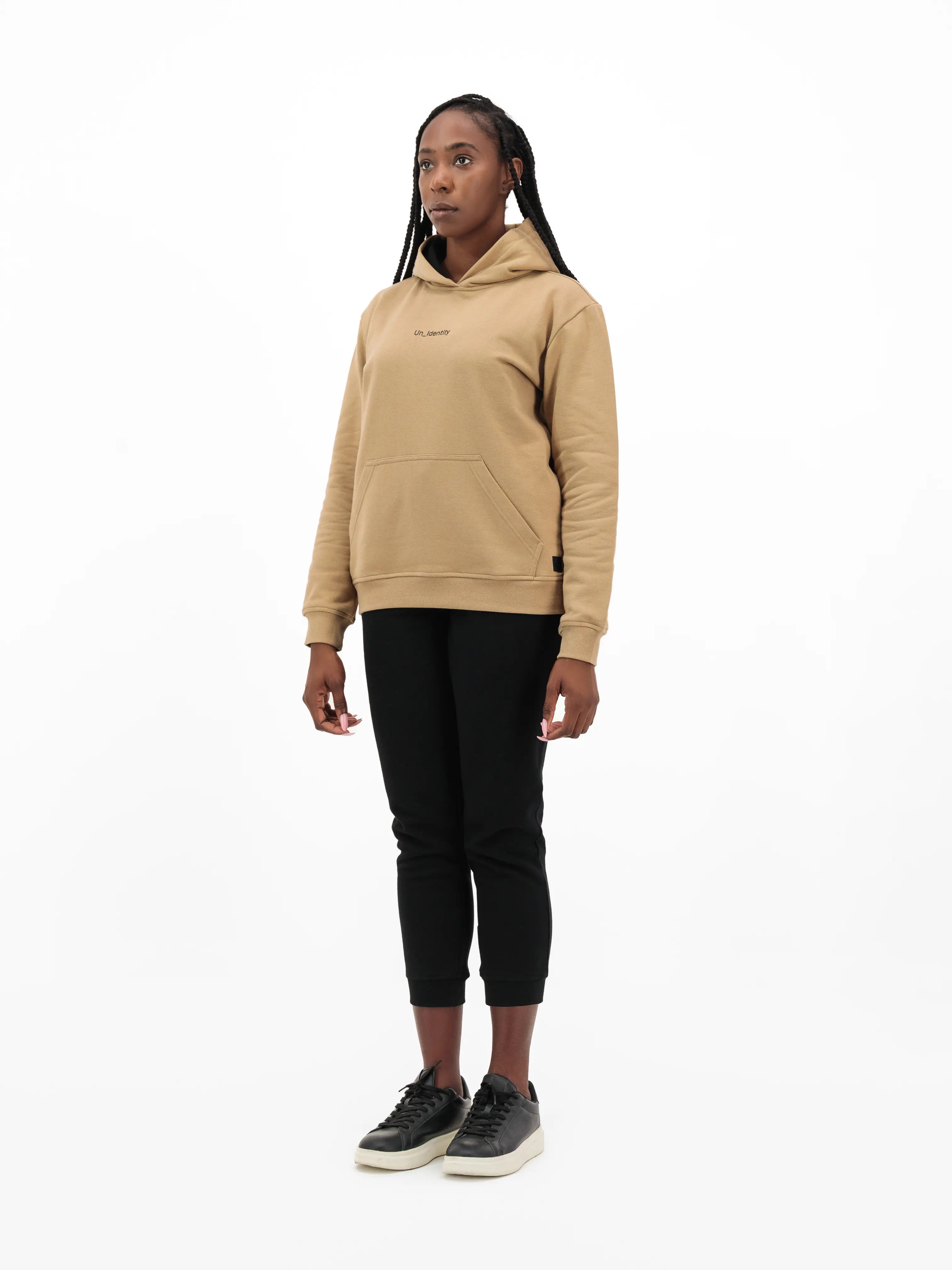 Woman wearing beige Unidentity hoodie and black pants. #color_beige