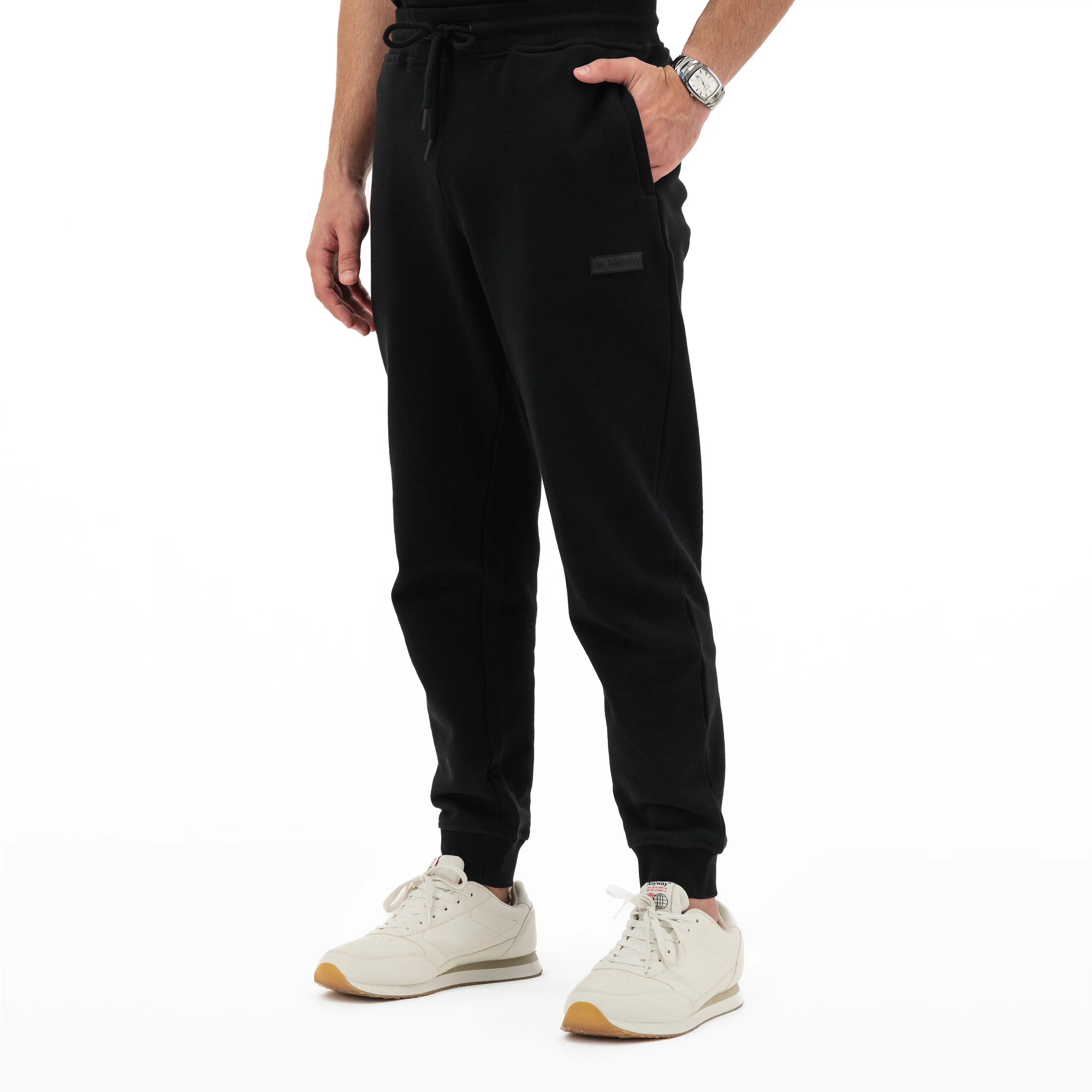 Person wearing black Unidentity jogger pants with drawstring and tonal logo