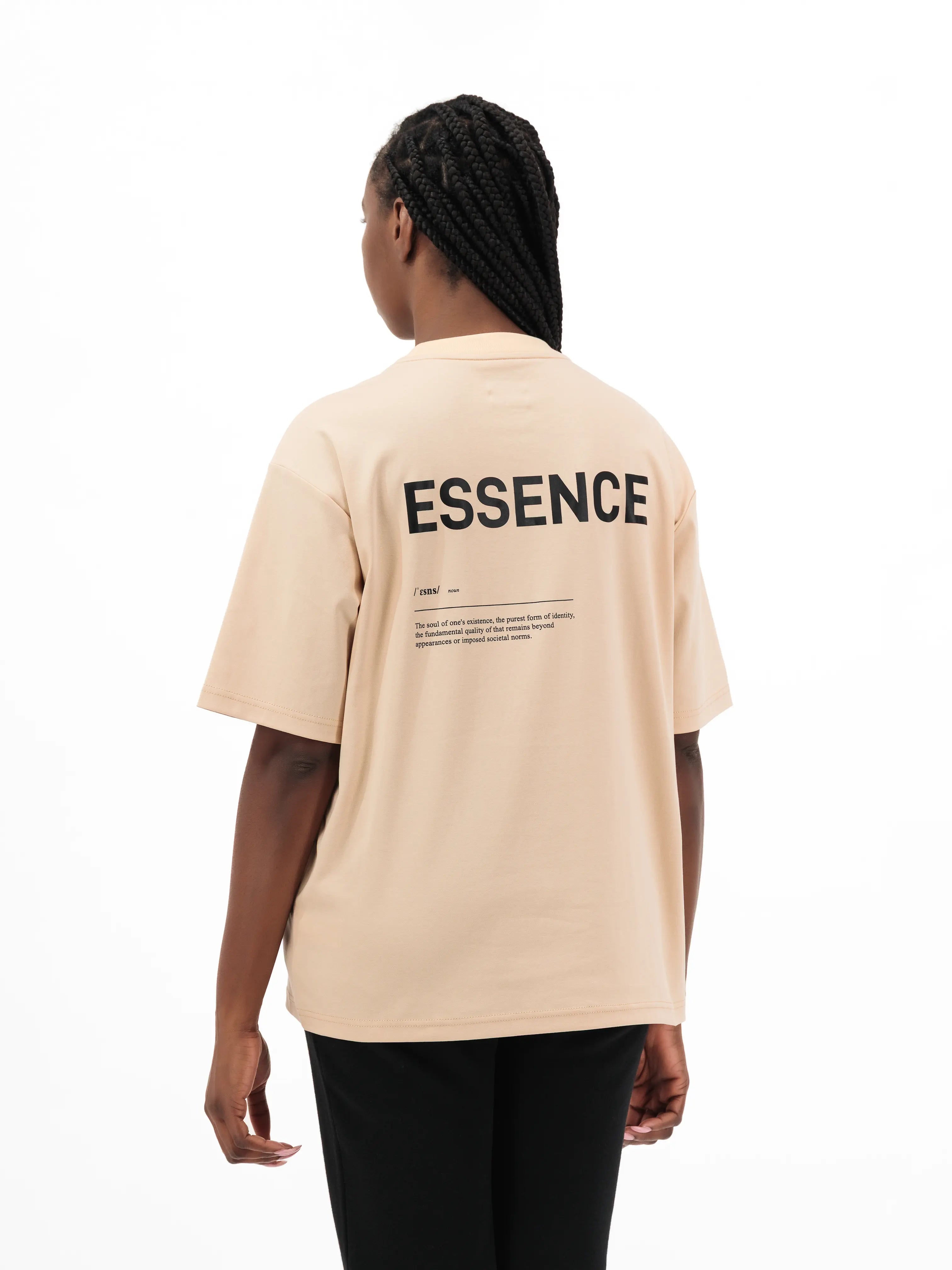 Person wearing beige Unidentity T-shirt with ESSENCE printed on the back. #color_beige
