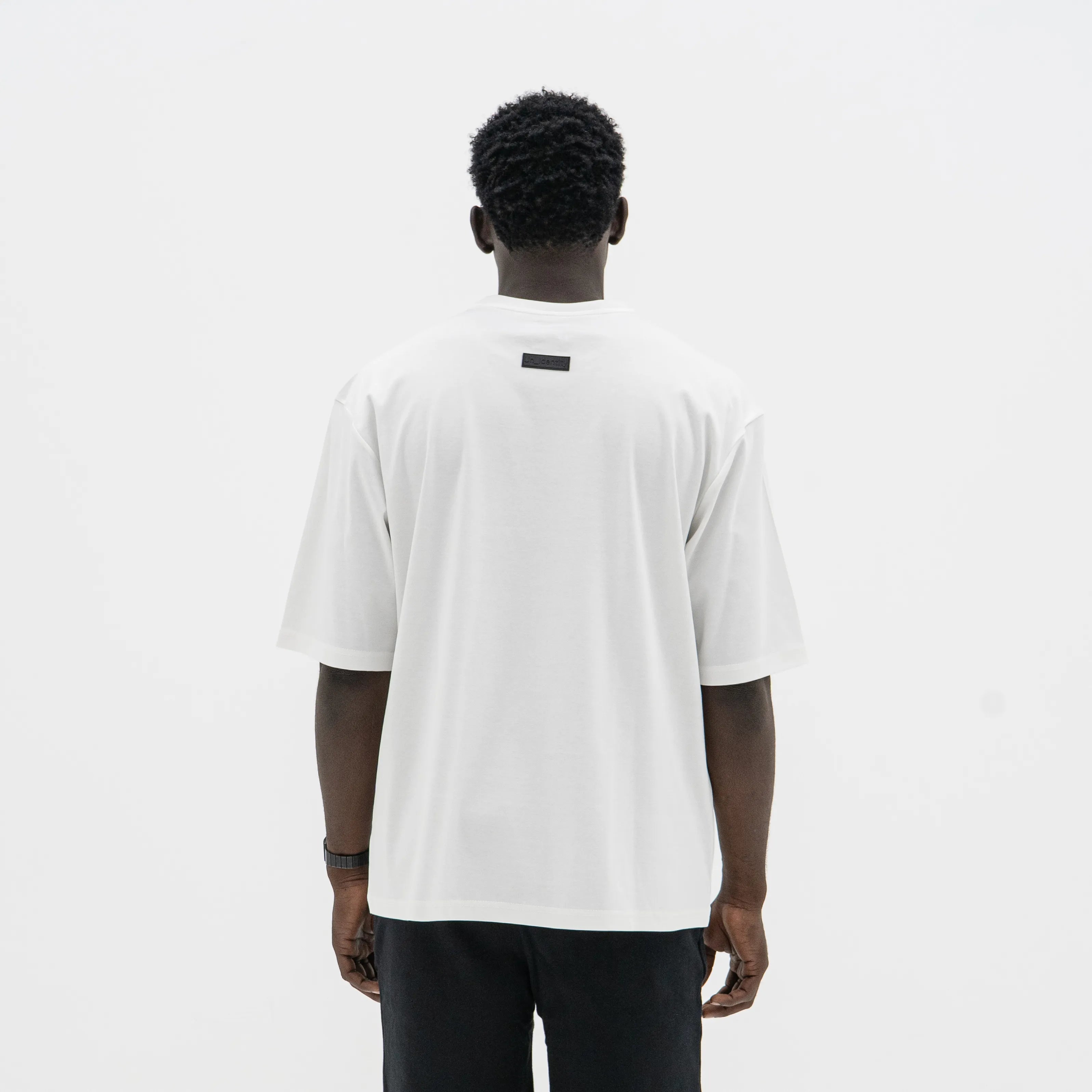 Person wearing a white t-shirt on a plain background. #color_white