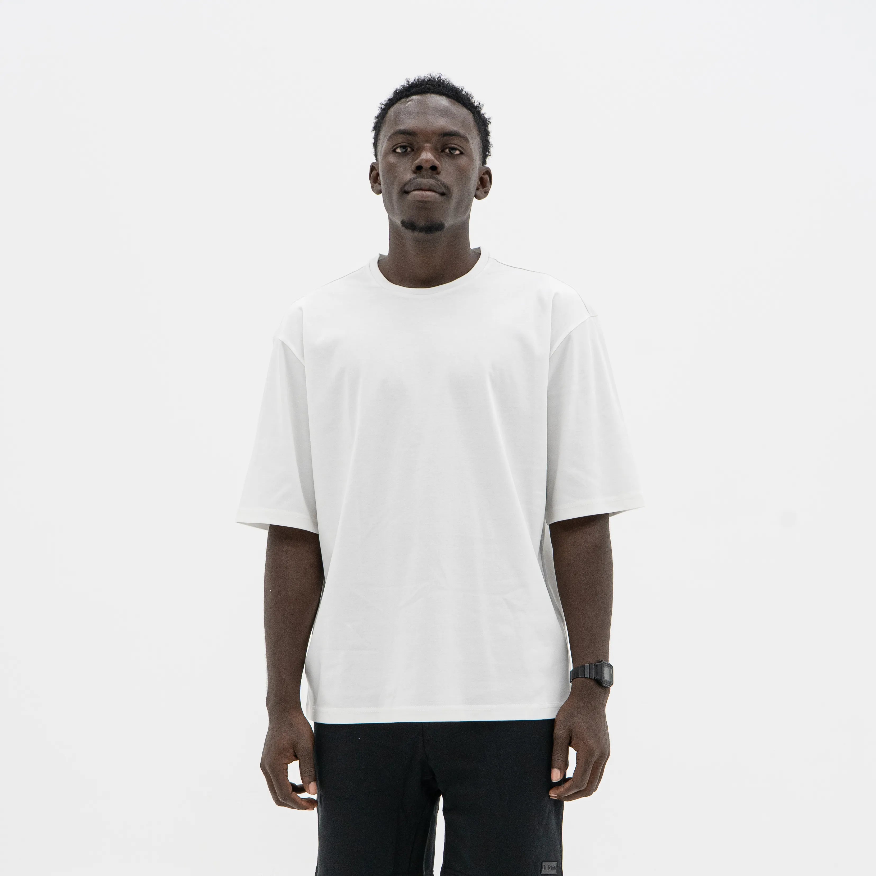 Man wearing a plain white t-shirt and black pants on a white background. #color_white