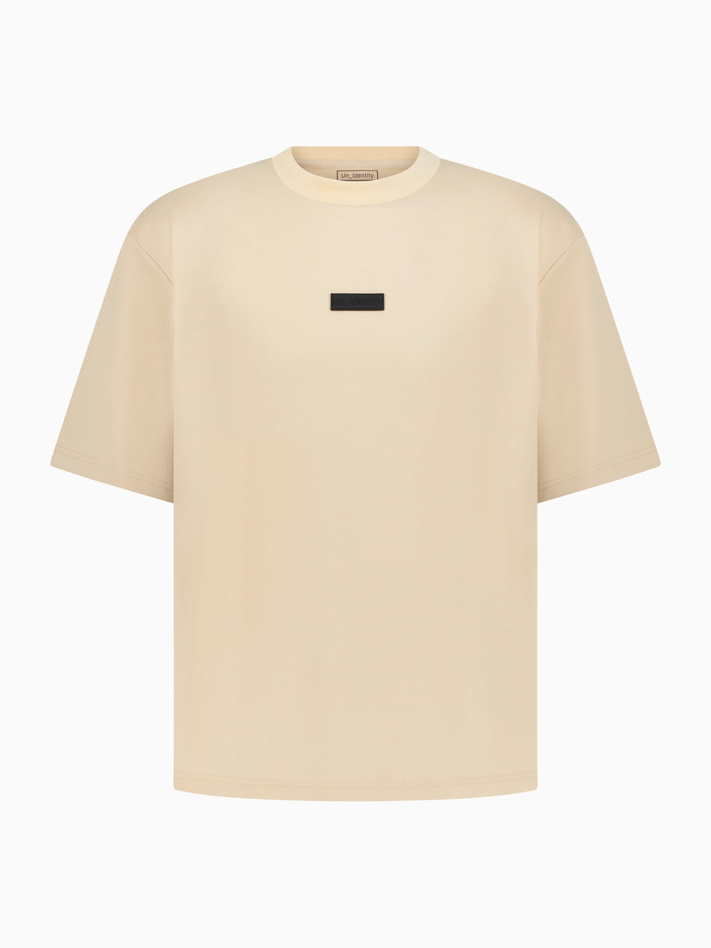 Beige Unidentity tee with small black label on the chest 