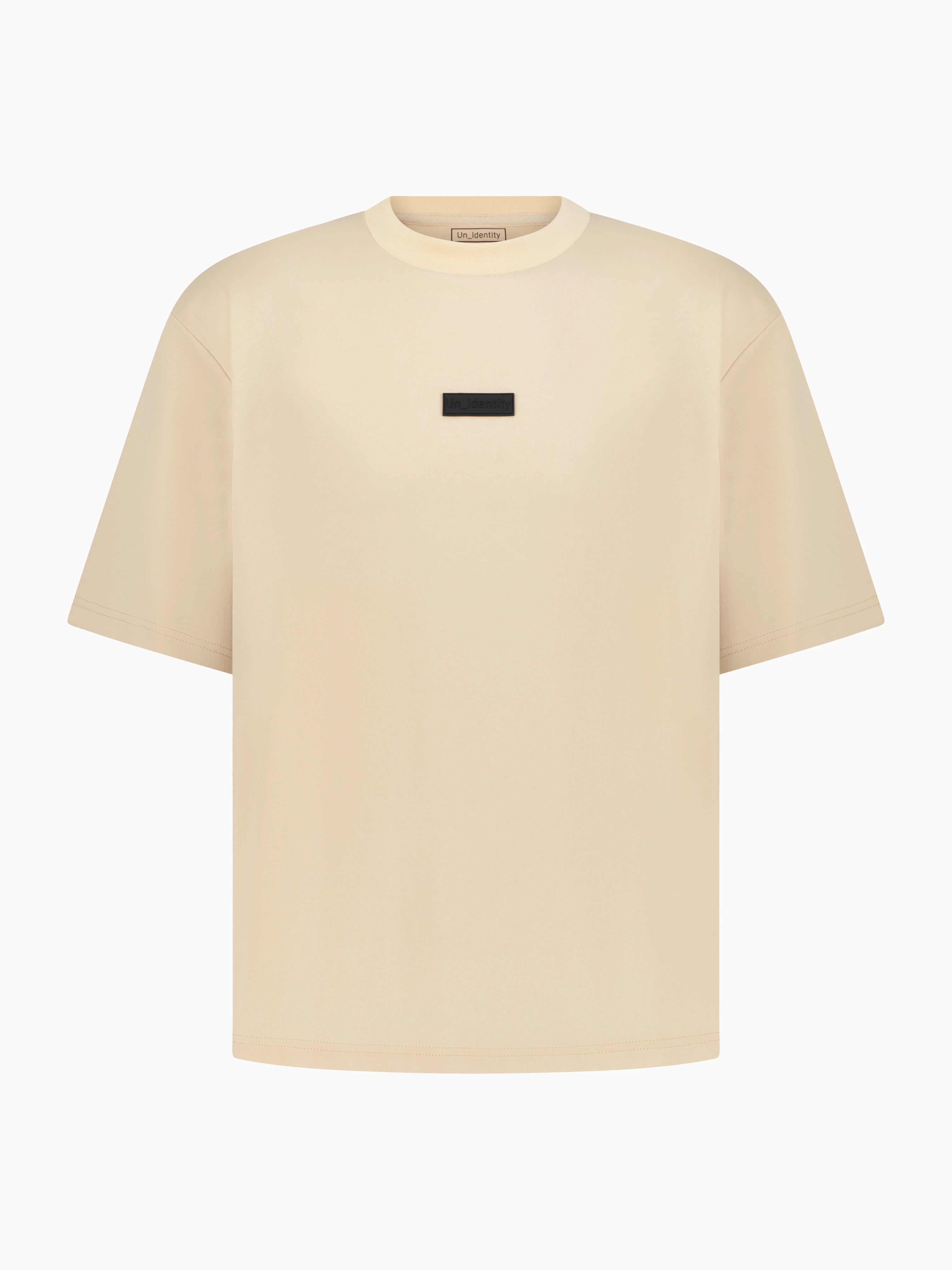 Beige Unidentity tee with small black label on the chest 
