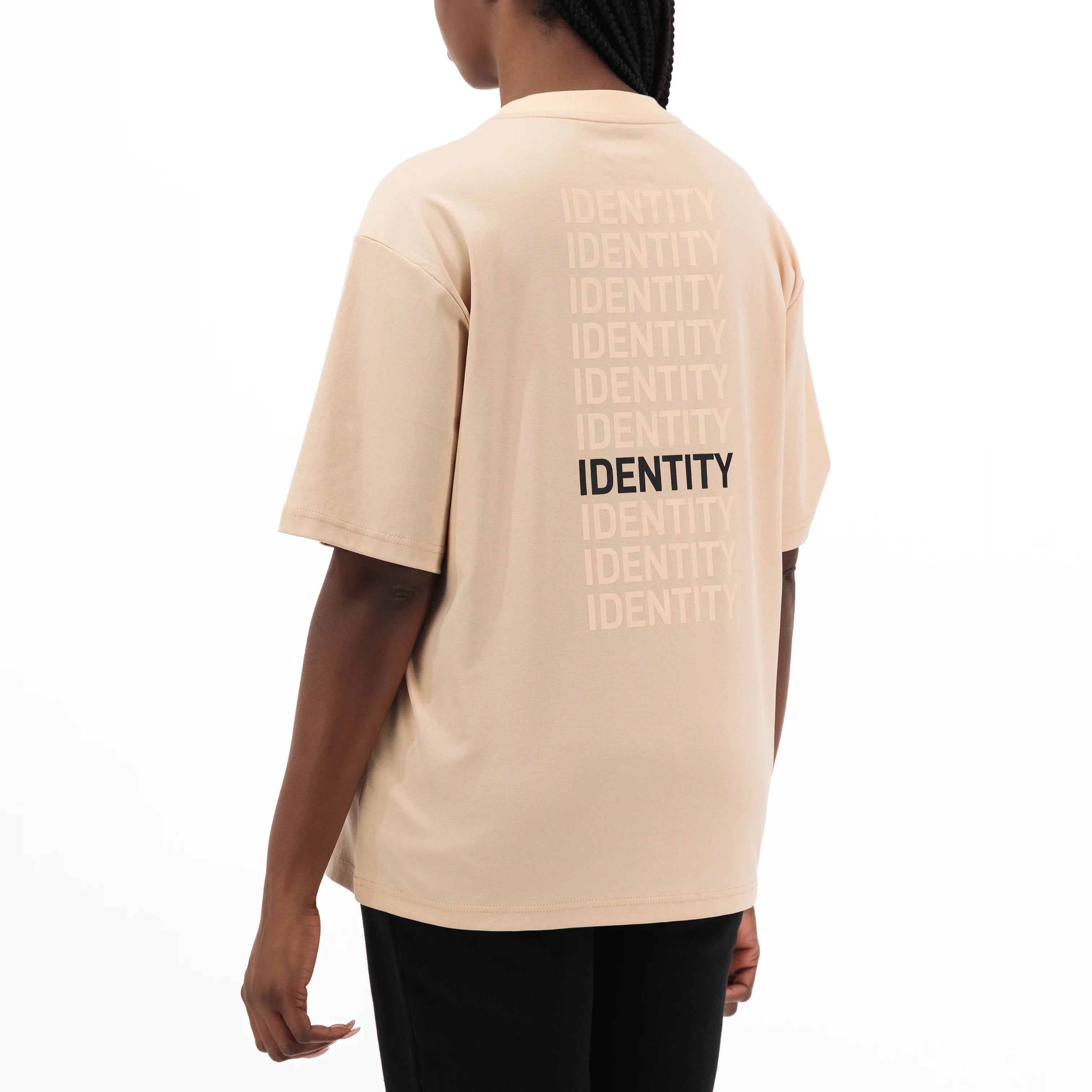 Person wearing beige Unidentity t-shirt with multiple identity texts on the back