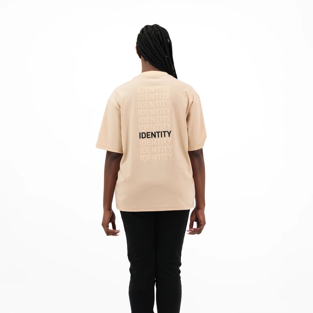 Model wearing beige t-shirt with identity text on the back 