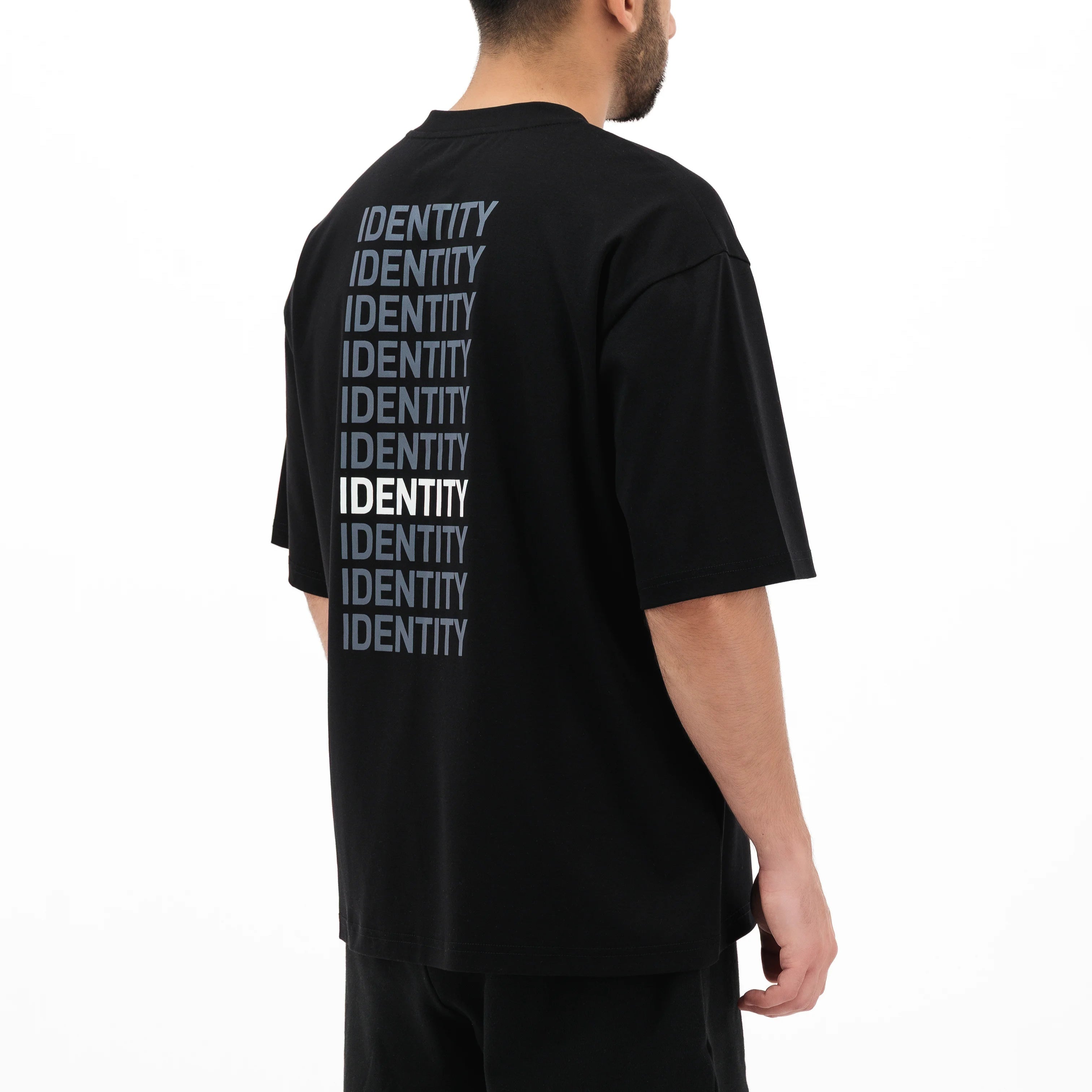 Person wearing black t-shirt with identity printed multiple times on the back